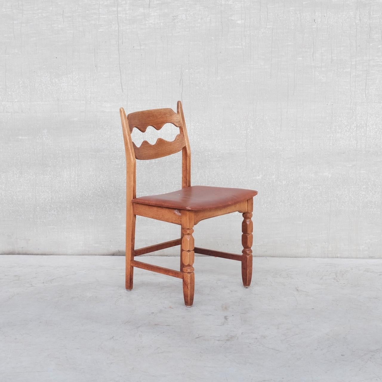 A set of four oak dining chairs by Henning Kjaernulf in original tan leather. 

Denmark, c1960s. 

'Razor back' or 'Razor blade' model. 

Generally good condition for the wood, some wear and scuffs commensurate with age. 

Original