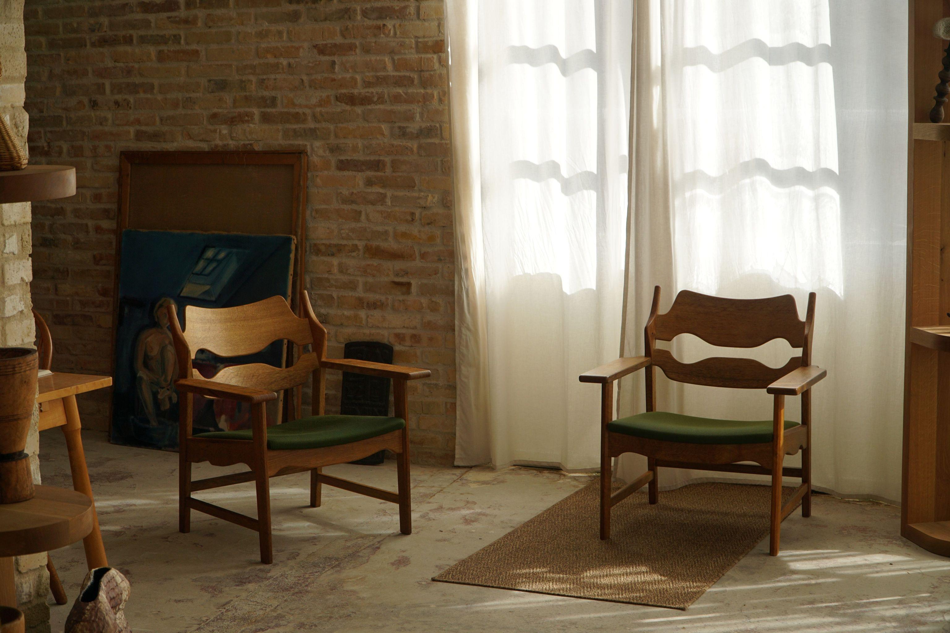 This pair of lounge chairs in oak designed by Henning Kjærnulf in the 1960s is a stunning piece of Danish Modern design. Made by E.G Kvalitetsmøbel, Denmark. Model 