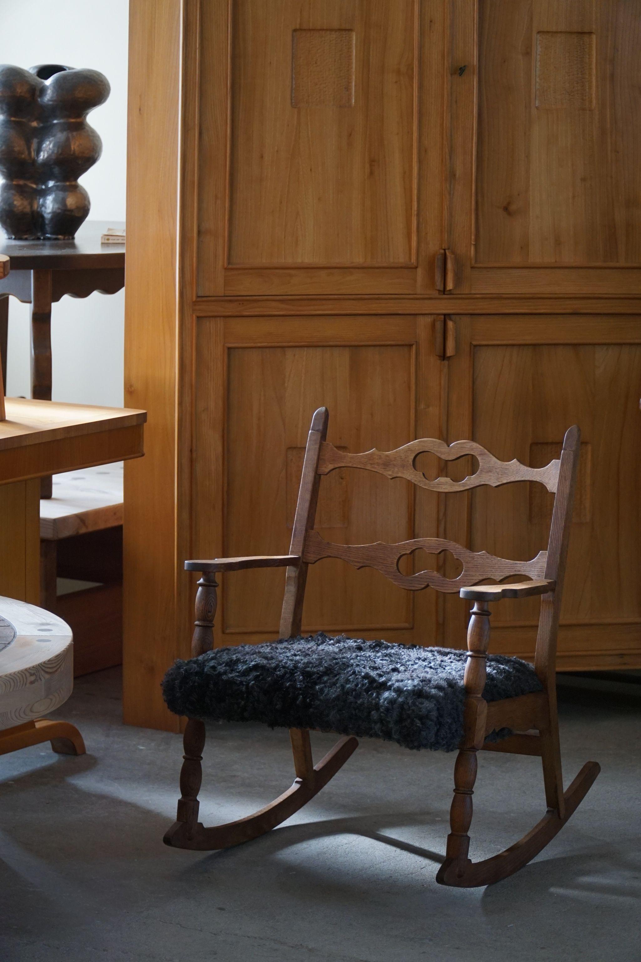 Schöner Schaukelstuhl aus massiver Eiche, Sitz mit Lammfell gepolstert. Entworfen von Henning (Henry) Kjaernulf für EG Kvalitetsmøbel, Dänemark 1960er Jahre.

Dieser schöne Stuhl passt zu vielen Einrichtungsstilen. Ein modernes, klassisches,