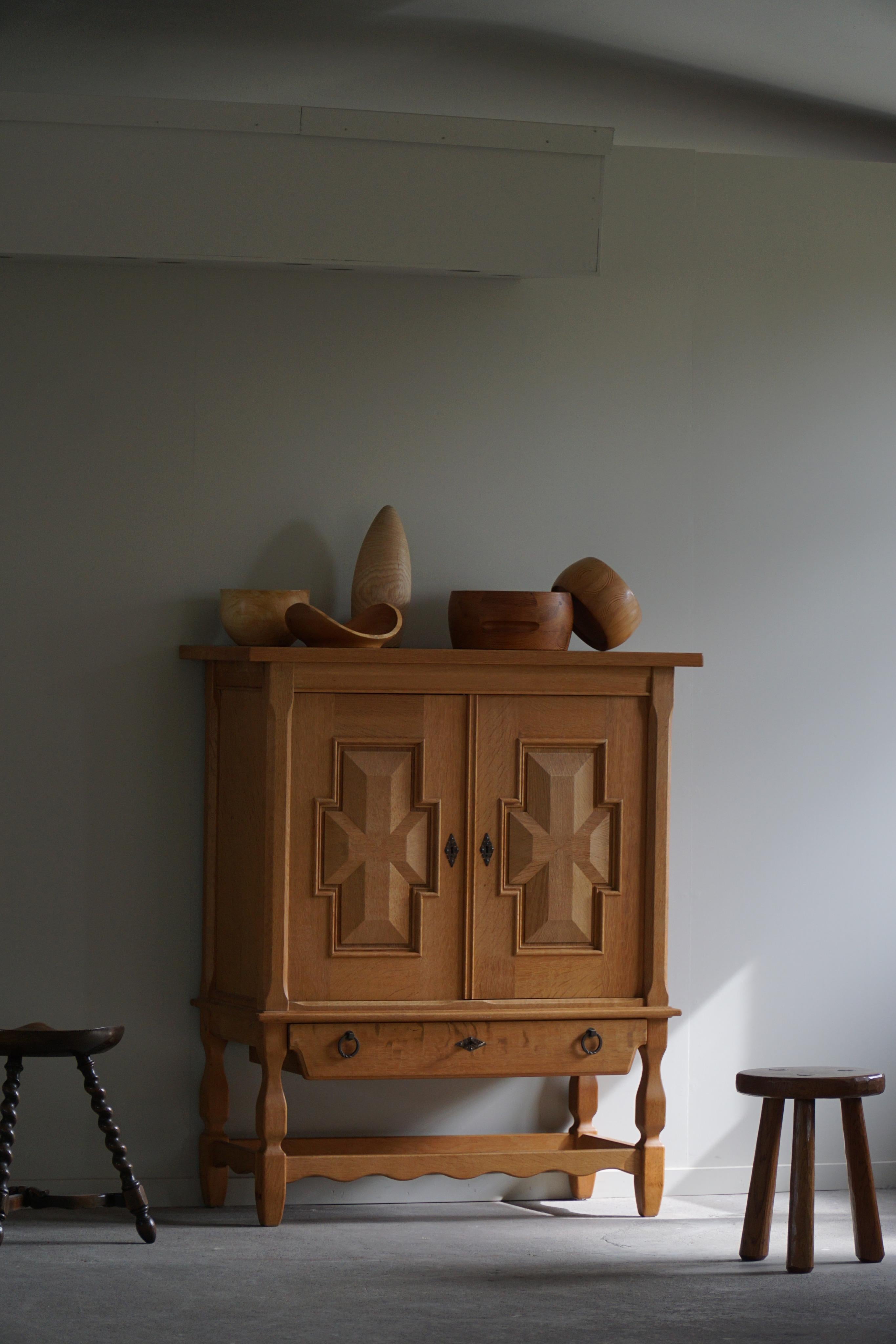A tall classic sideboard / cabinet in oak with great storage space. Designed by Henning (Henry) Kjærnulf for E.G møbler in 1960s. A nice sculptural front pattern.

This fine brutalist cabinet will complement many interior styles. A modern,