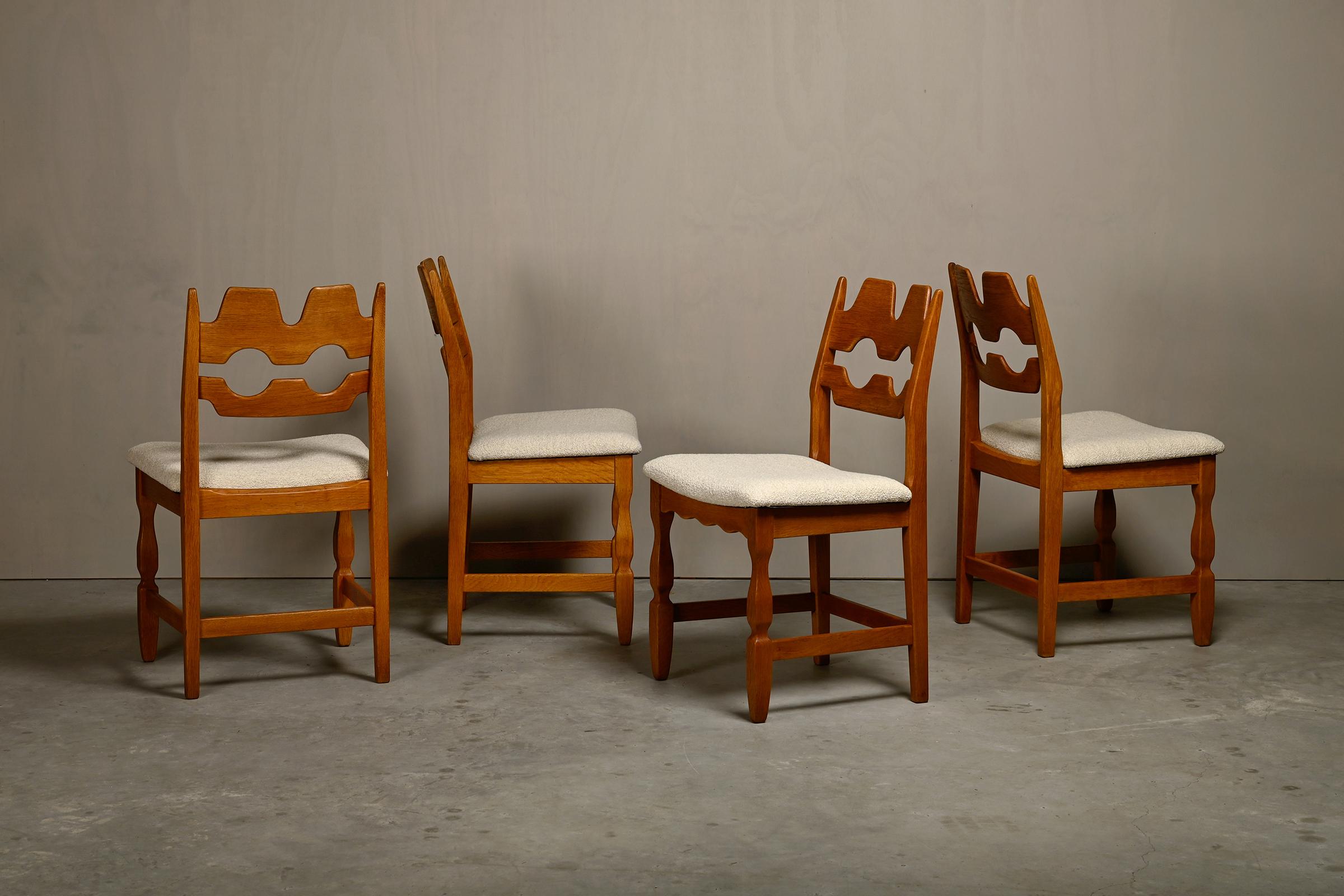 Beautiful set of 4 sculptural dining room chairs (Model 54) designed by Henning Kjærnulf for Nyrup Møbelfabrik, Denmark in the 1960s. Solid oak frames with bouclé upholstered seats. The solid oak frames are sturdy, cleaned, refinished and in very