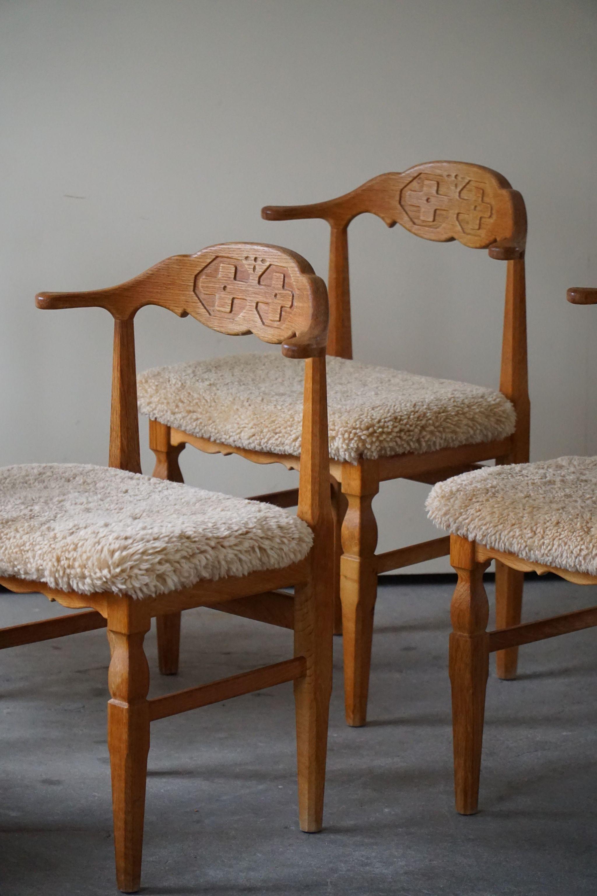 Such a magnificent set of 6 dining chairs in oak, seats reupholstered in great quality shearling lambswool. 
Designed by Henning Kjærnulf for E.G. Møbler - circa 1960s.

The overall impression of these midcentury chairs are really good.
This set