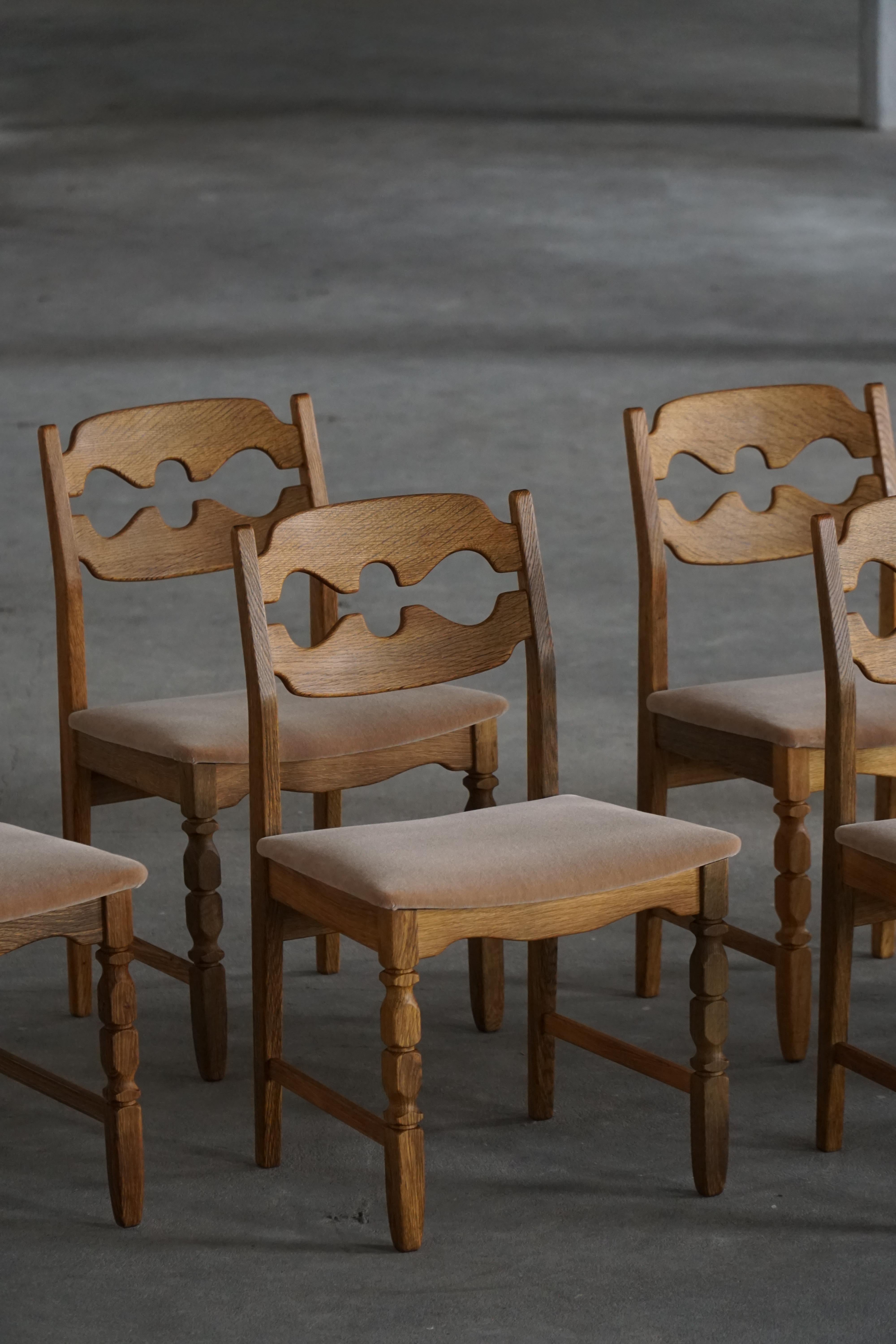An exceptional set of eight dining chairs designed by Henning Kjærnulf for Nyrup Møbelfabrik, Denmark, in the 1960s. Known as the celebrated “Razorblade” model, these chairs are distinguished by their sculptural oak backrests, finely carved with the