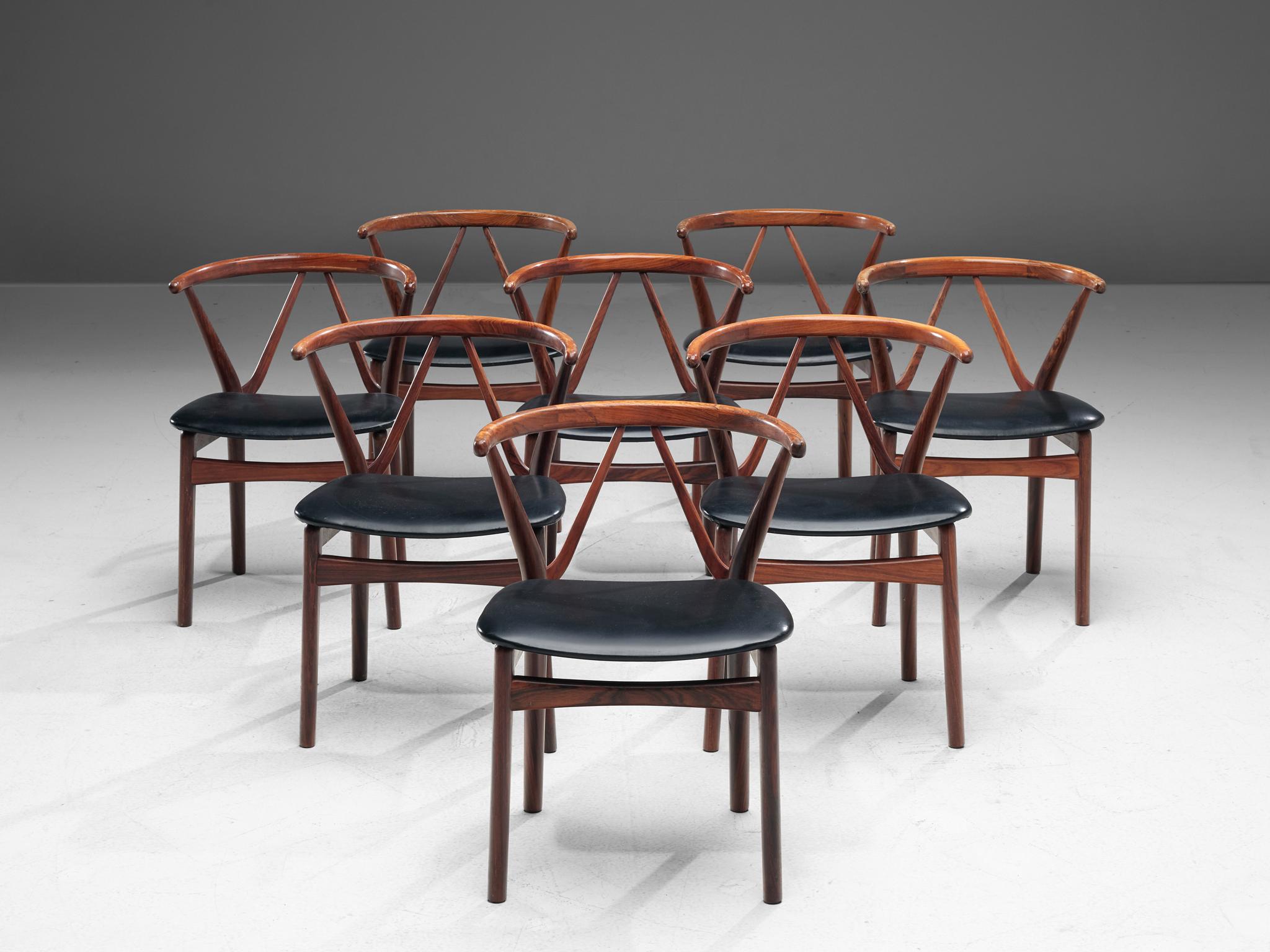 Henning Kjaernulf for Bruno Hansen, set of eight dining chairs model 255, in rosewood and faux-leather, Denmark, 1950s. 

Set of eight elegant dining chairs with strong resemblance to the designs of Hans Wegner. These solid rosewood chairs have a