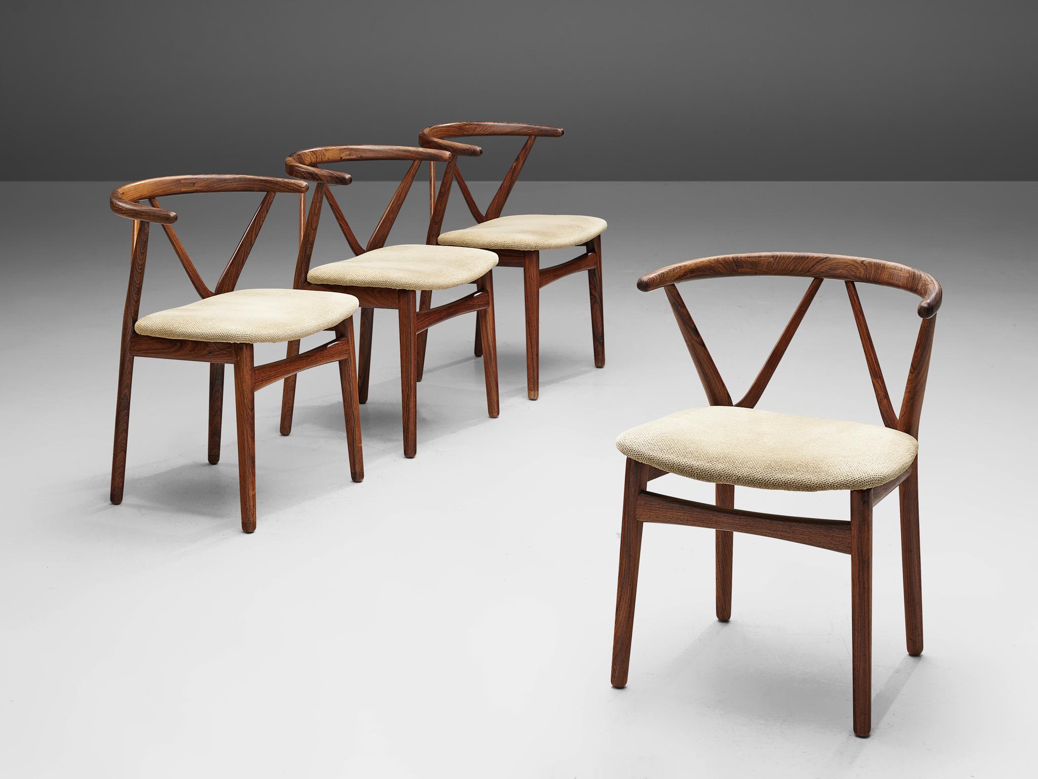 Henning Kjaernulf for Bruno Hansen, set of four dining chairs model 255, rosewood, off-white textured upholstery, Denmark, 1950s. 

Set of four elegant dining chairs made out of rosewood with a beautiful curved back. The diagonal support of the