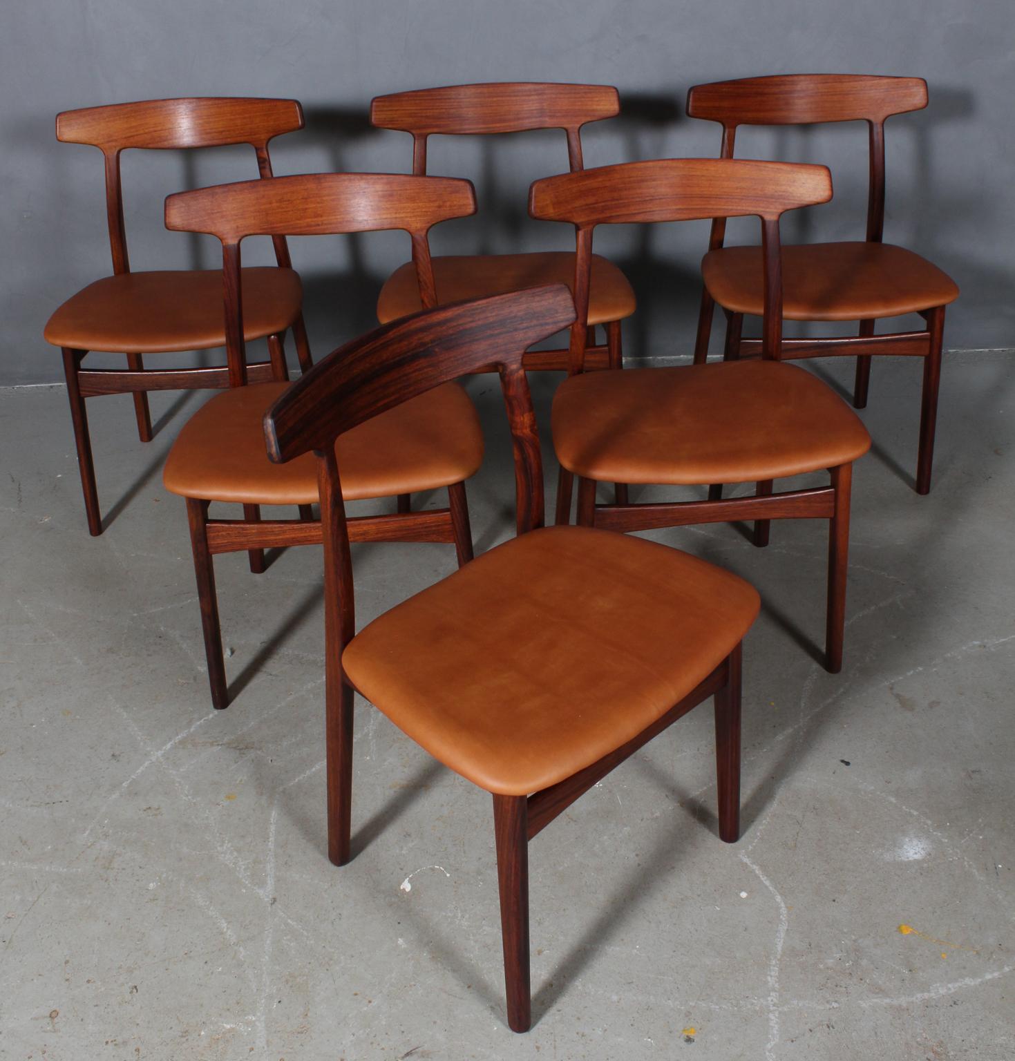 Henning Kjærnulf six dining chairs, upholstered with tan aniline leather.

Frame of solid rosewood.

Made by Bruno Knudsen.