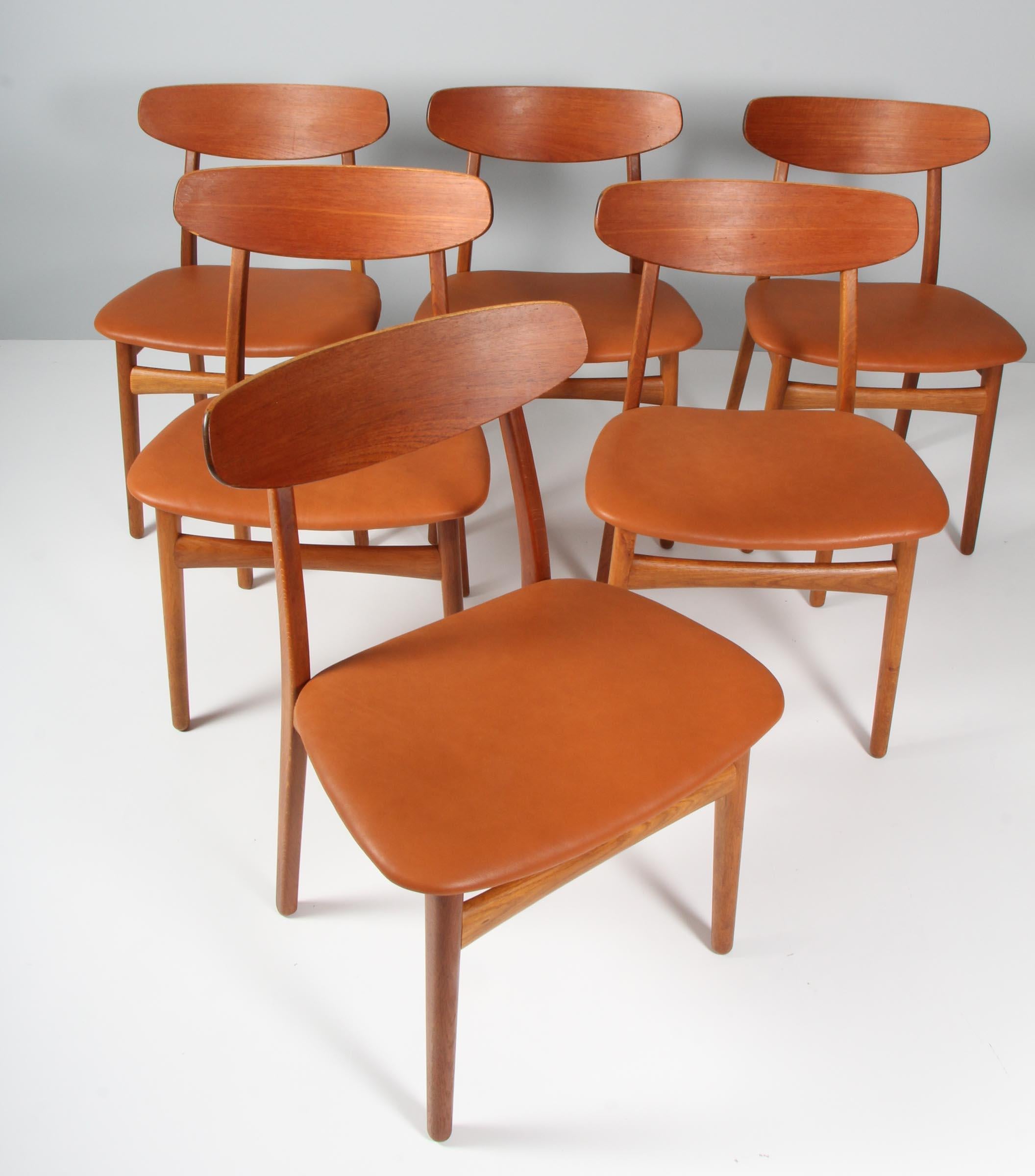 Henning Kjærnulf six dining chairs, upholstered with aniline leather.

Made of oak and teak.

Made by Bruno Hansen.