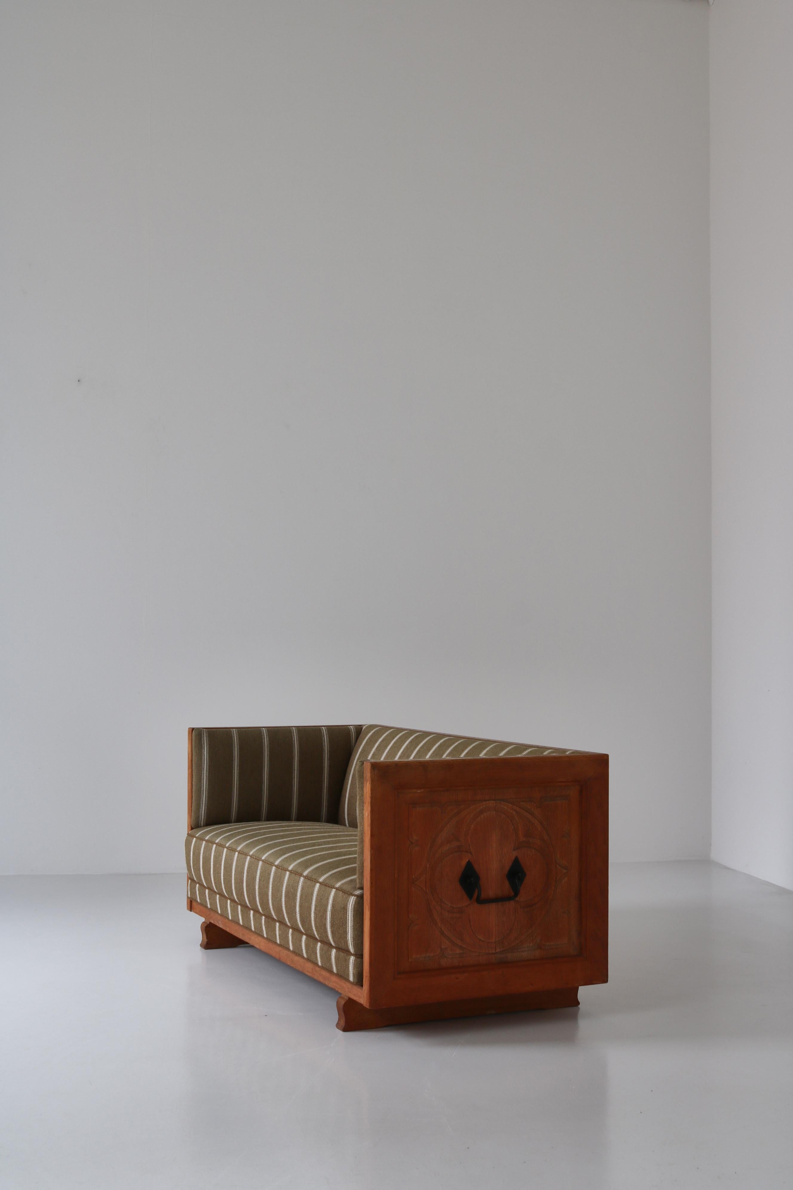 Rare and amazing sofa attributed to Danish architect Henning Kjærnulf made in Denmark in the 1960s. It is made from carved solid oak and upholstered in the original beautiful striped Savak Wool. The sofa is a modernist take on the traditional Danish