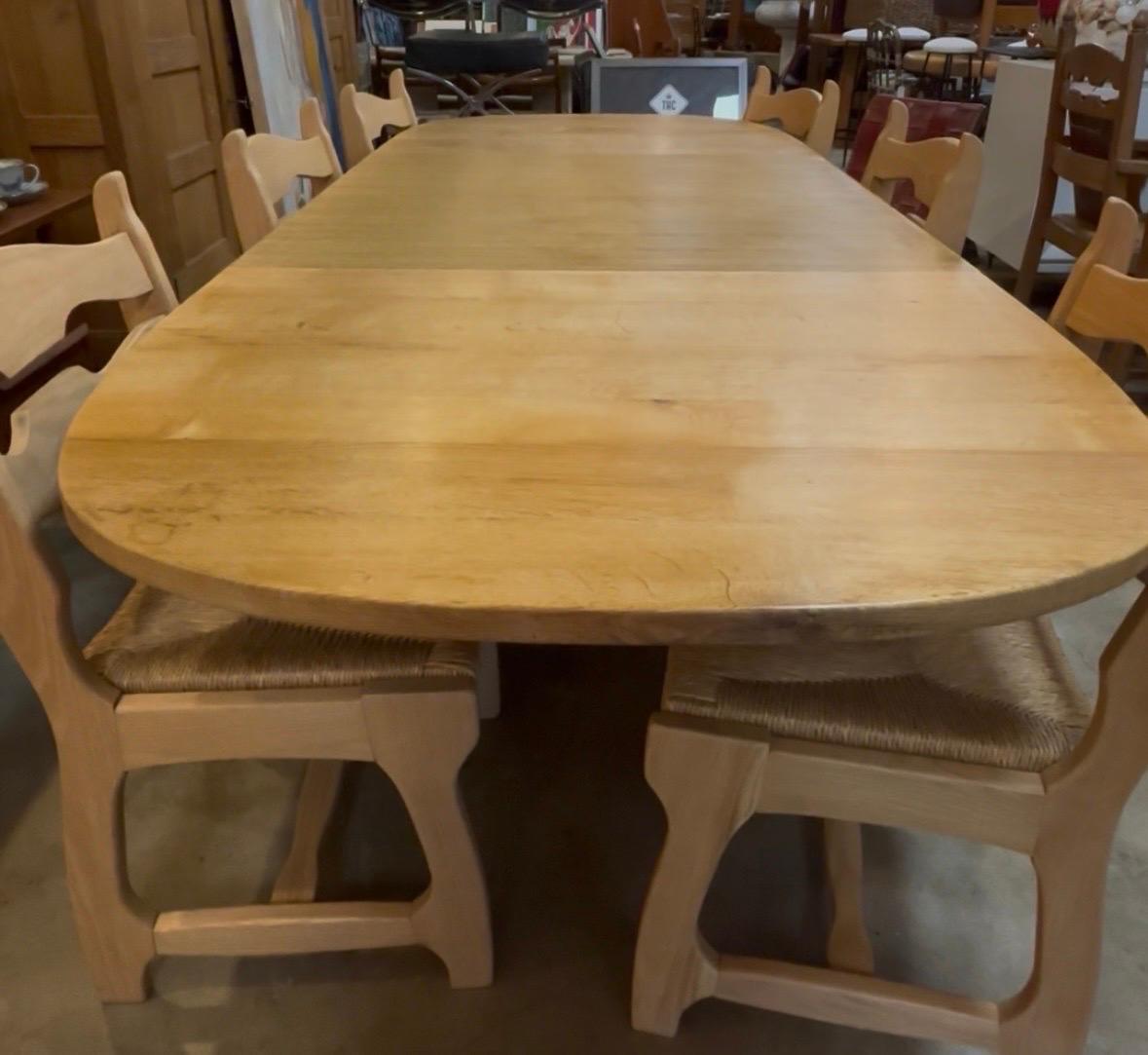 Tavolo da pranzo moderno danese Henning Kjærnulf in rovere massiccio con due foglie rimovibili, anni '70 circa. Caratterizzato da intagli dettagliati sulle gambe dal design scultoreo, questo tavolo da pranzo di metà secolo è in ottime condizioni