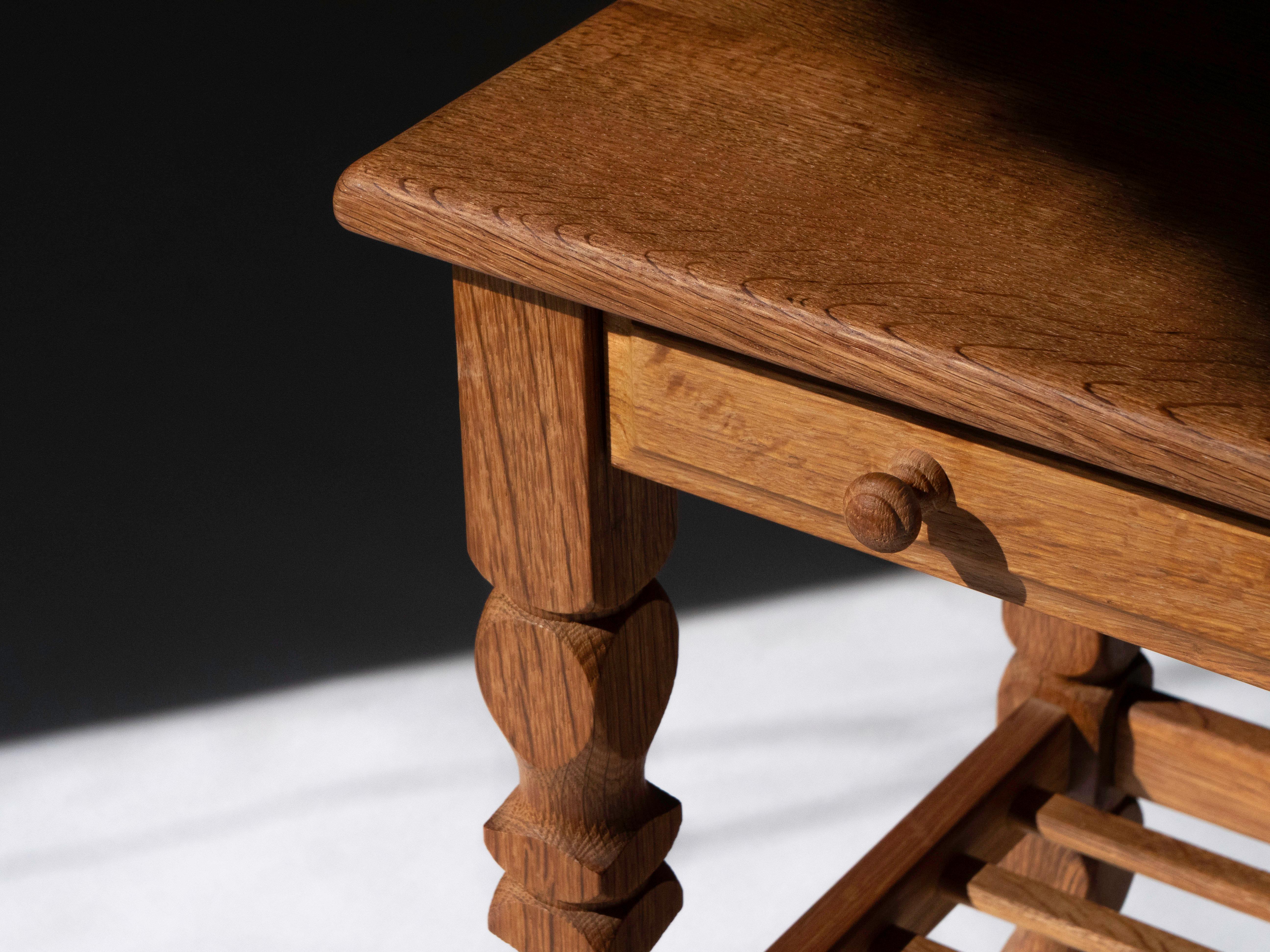 Ein Beistelltisch aus massiver Roteiche von Designer Henning Kjaernulf. Hergestellt in Dänemark in den 1960er Jahren. 

Sehr detailliert gearbeiteter Tisch mit geschnitzten Beinen, abgerundeten Kanten, einer schwalbenschwanzförmigen Schublade und