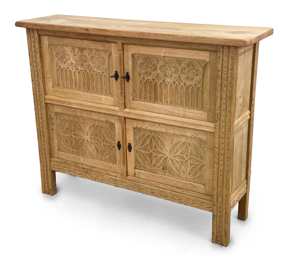 Behold the majesty of a bygone era, beautifully juxtaposed with the elegance of Scandinavian design: the Henning Kjærnulf-Style Carved Oak Sideboard Cabinet. A piece that is as much an objet d'art as it is a functional furnishing, this sideboard