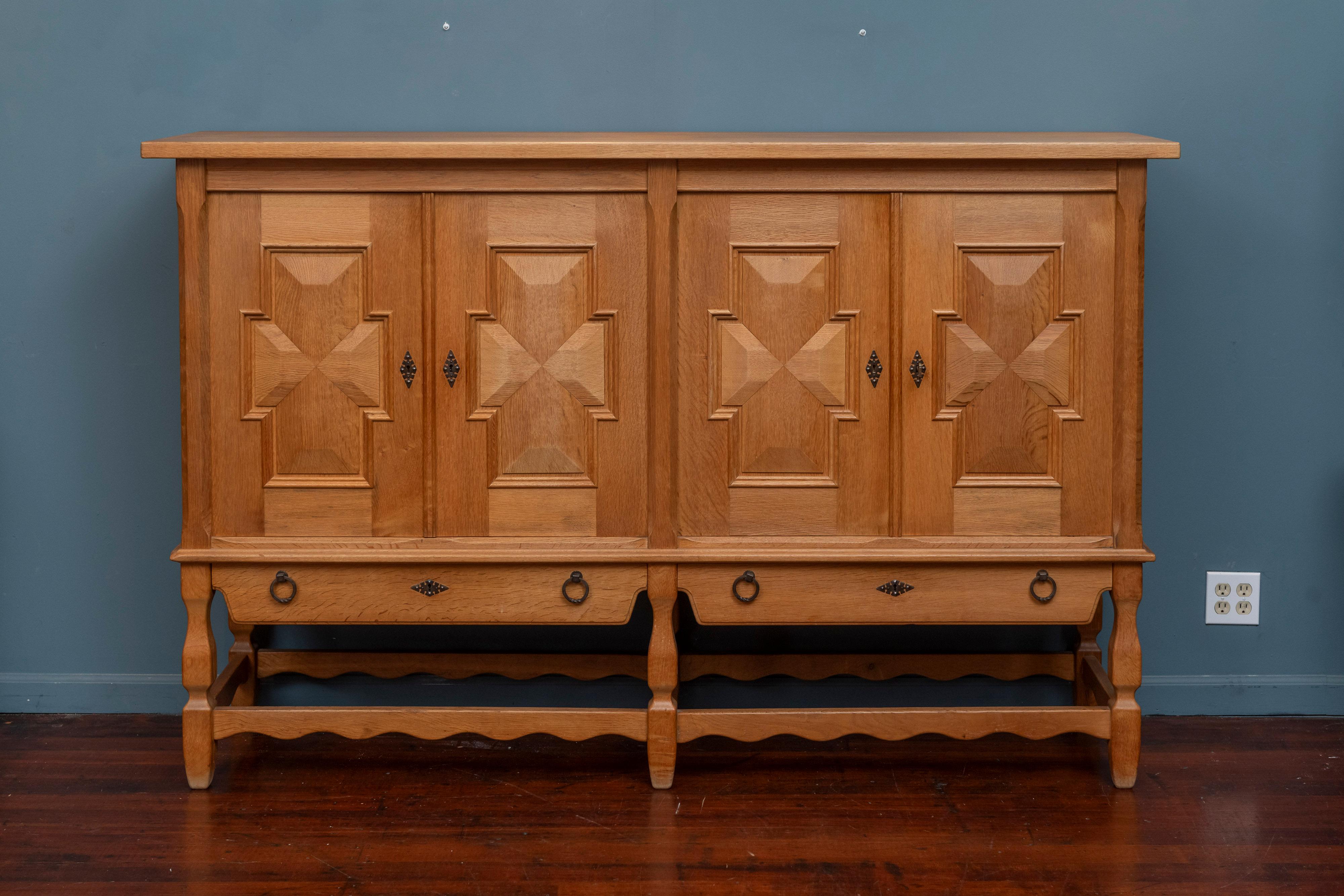Henning Kjaernulf design cabinet or buffet, Denmark. High quality construction and use of materials in solid oak with metal mounts. A great storage cabinet or used as buffet with carved panels and details with fitted interiors comprising drawers and
