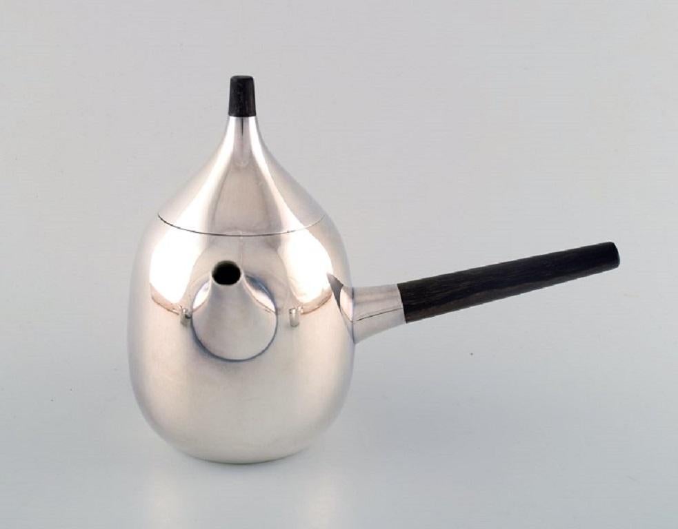 Henning Koppel for Georg Jensen 1945-1977. 
Coffee service in sterling silver consisting of coffee pot, cream pot and sugar bowl.
Dessin 1091.
Handles and knob in dark wood. 
In very good condition.
The coffee pot measures: 23 cm x 17, 5