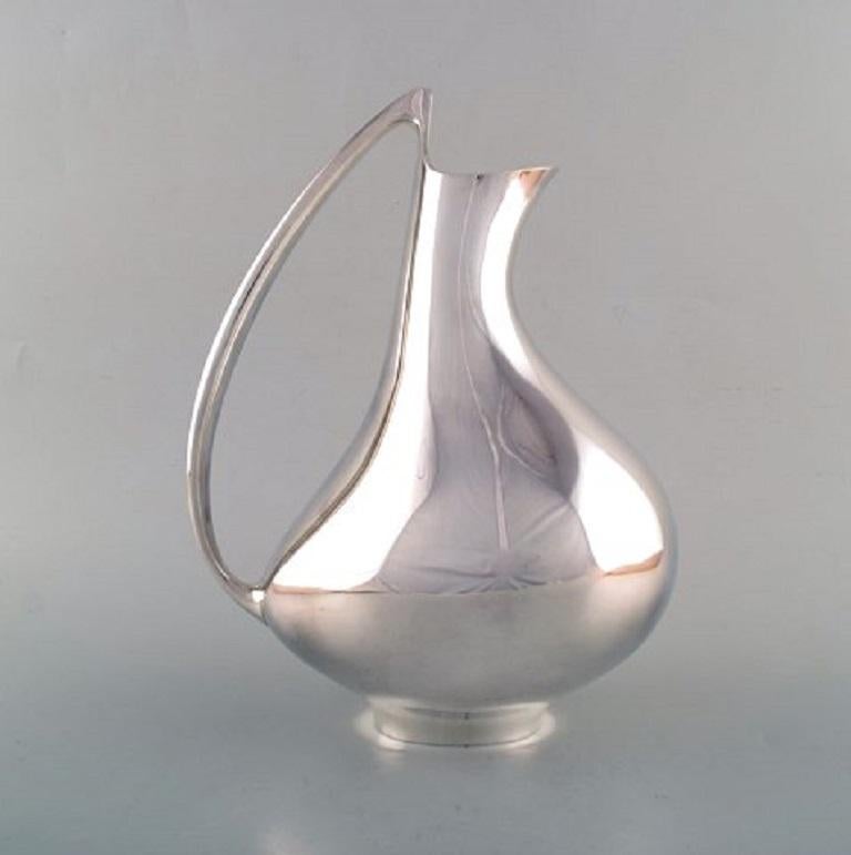 Henning Koppel for Georg Jensen. Modernist sterling silver jug. 'The Pregnant Duck'. Model number 992. Designed by Henning Koppel in 1951.
Measures: 29.5 x 21.5 cm.
In very good condition.
Weight approx. 1348 gr.
Stamped.
Literature: Janet