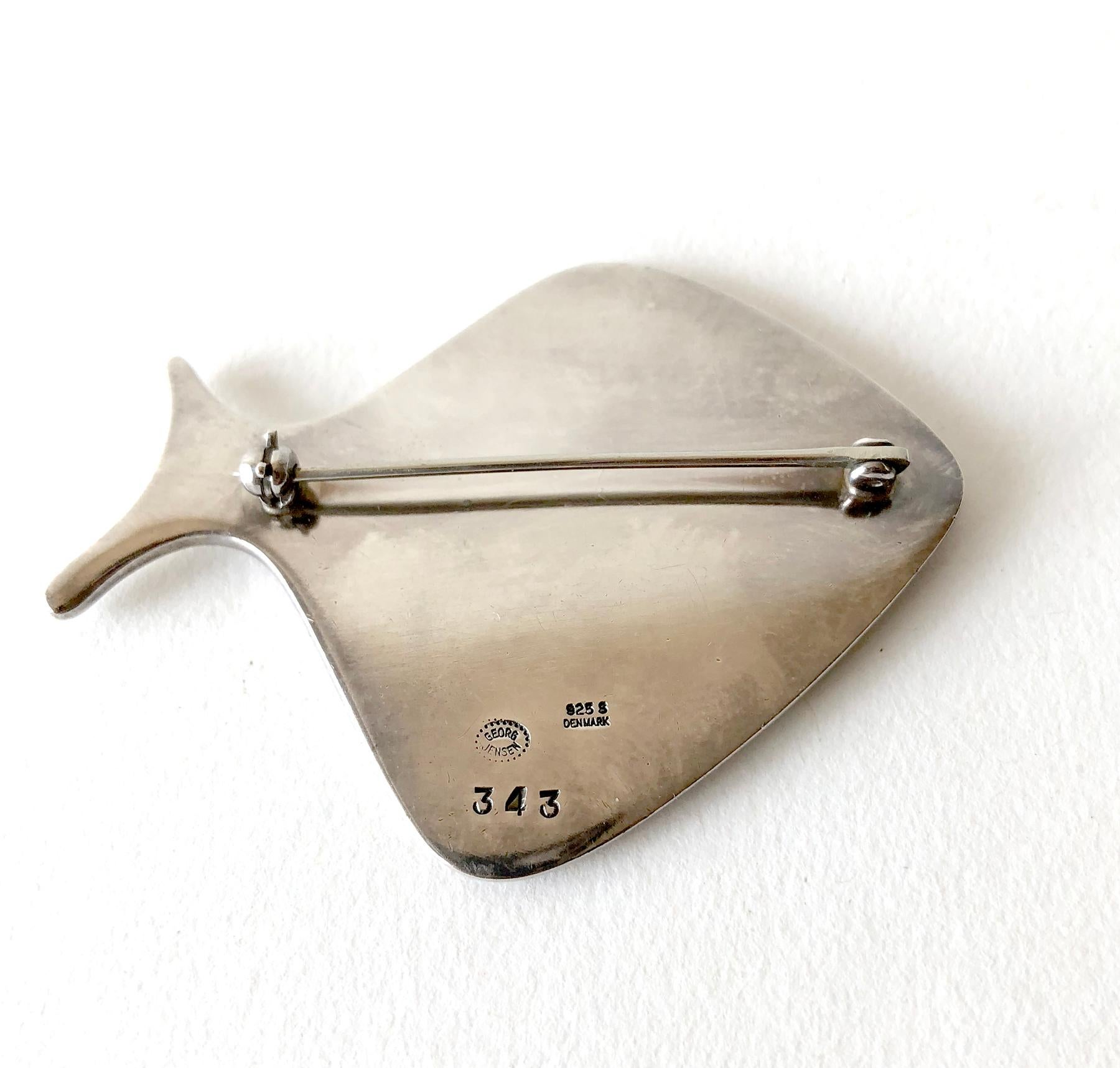 Iconic Danish modernist sterling silver fish brooch by Henning Koppel for Georg Jensen.  Brooch measures 1 3/4 by 2 3/8