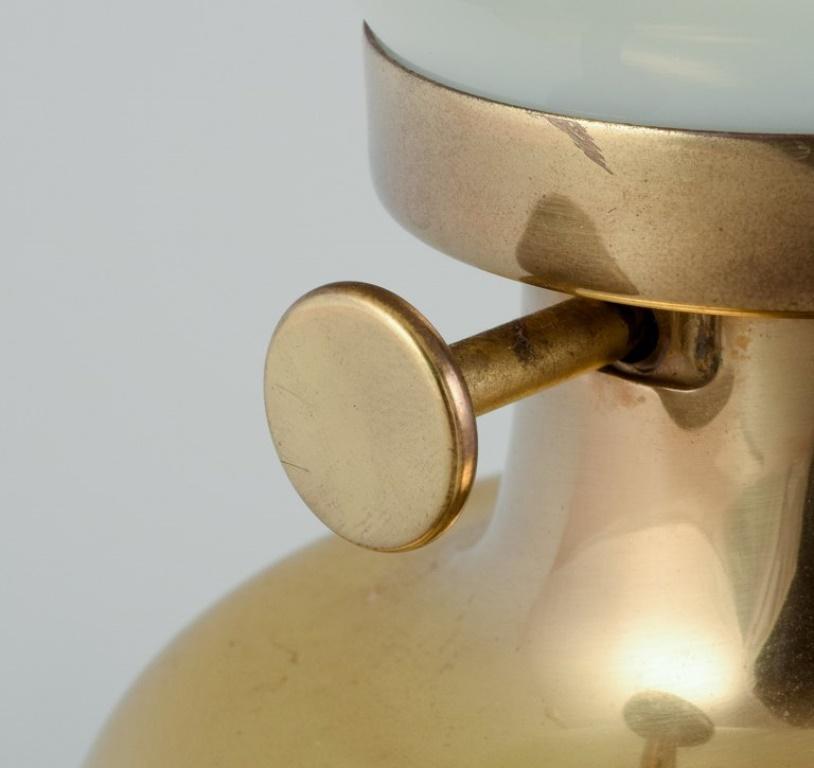 Danish Henning Koppel for Louis Poulsen. Petronella oil lamp in brass with glass shade