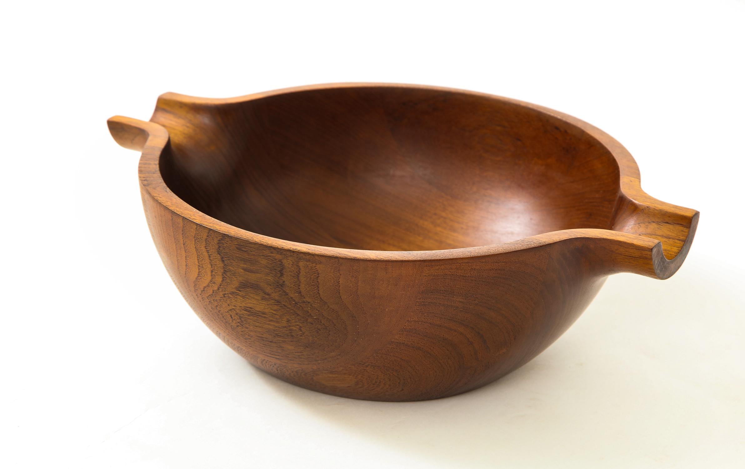 Centerpiece bowl in nicely figured staved teak designed by Henning Koppel and produced for Georg Jensen, circa 1960s. The striking rounded canoe-shaped form has been refinished and presents beautifully. With impressed marks 