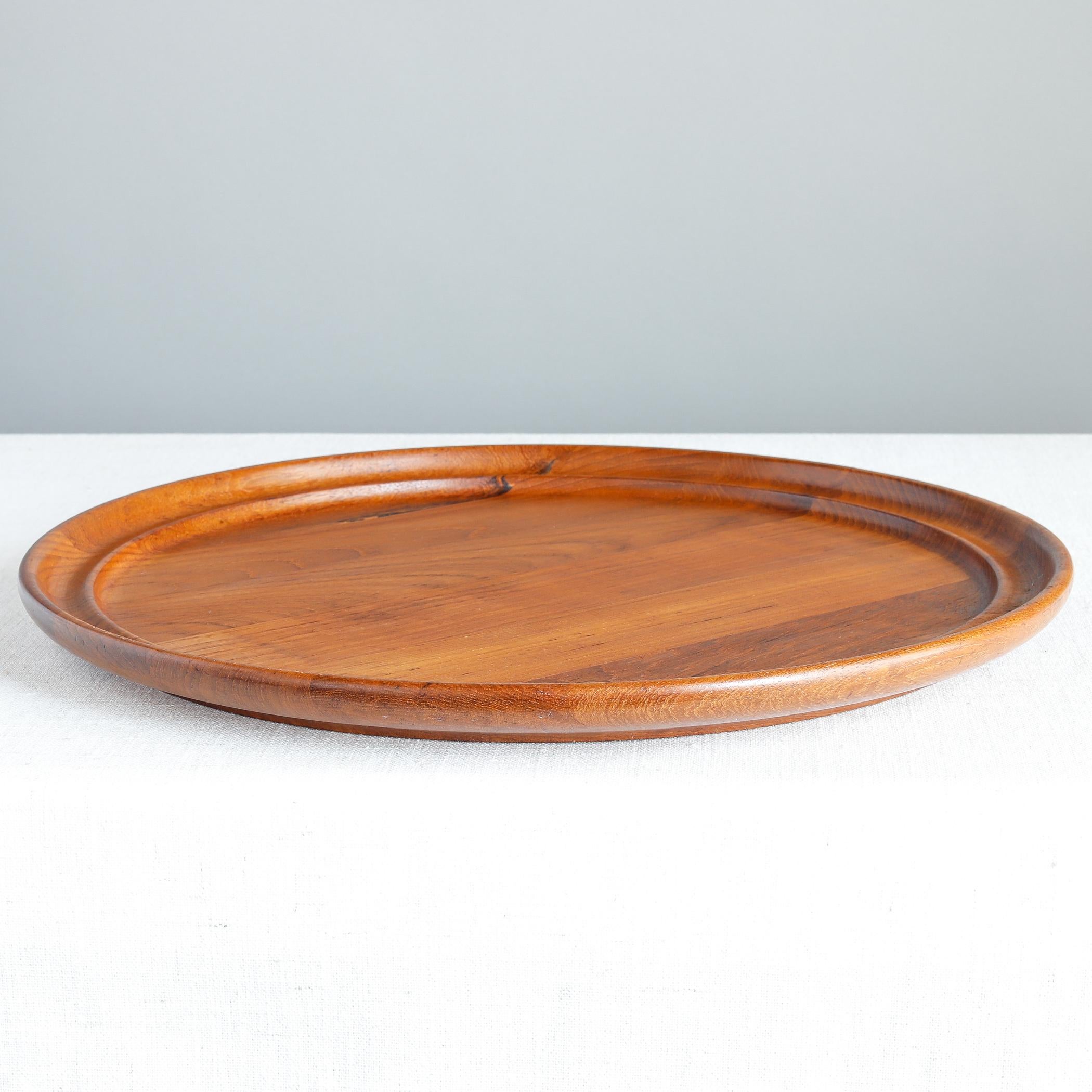 Staved teak tray designed by Henning Koppel for Danish retailer Georg Jensen. The round tray has a shaped rim, which was seen on all the pieces from this line. 

Provenance: this tray was owned by Bobbie de Marneffe of Massachusetts, a noted