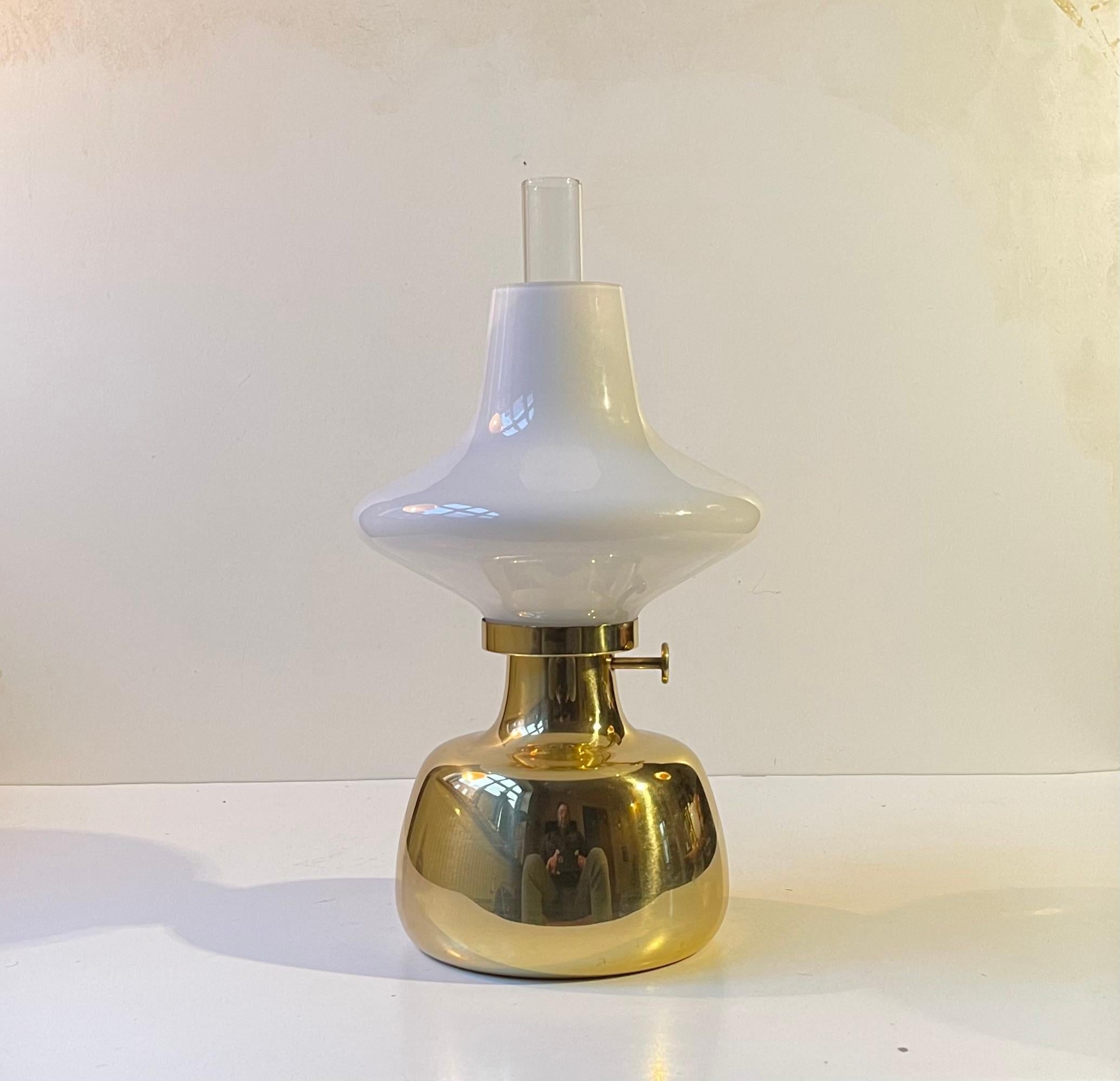 Designed by Henning Koppel (1918-81) and manufactured by Louis Poulsen in the 1960s this early series Petronella oil lamp is made from solid brass and has an opaline glass shade and its original clear glass chimney. Its Mechanically sound and
