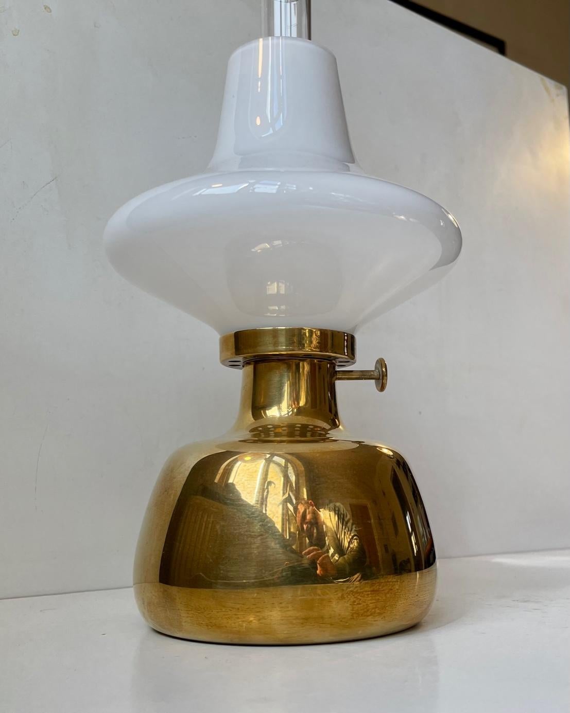 Conçue par Henning Koppel (1918-81) et fabriquée par Louis Poulsen dans les années 1980, la lampe à huile Petronella est fabriquée en laiton massif et possède un abat-jour en verre opalin. En raison de la composition de son matériau, il convient