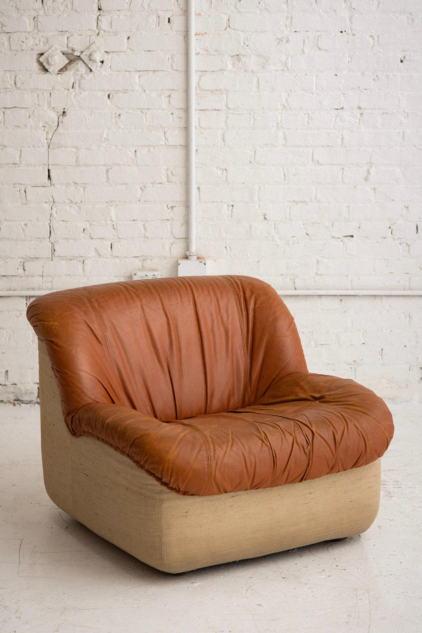 A midcentury Italian leather “Caprice” chair by Henning Korch for Swan. Leather upper and textured beige woven fabric bottom. 6 available, sold individually. Can be used separately or placed together as modular seating. Retains original “Swan” tag.