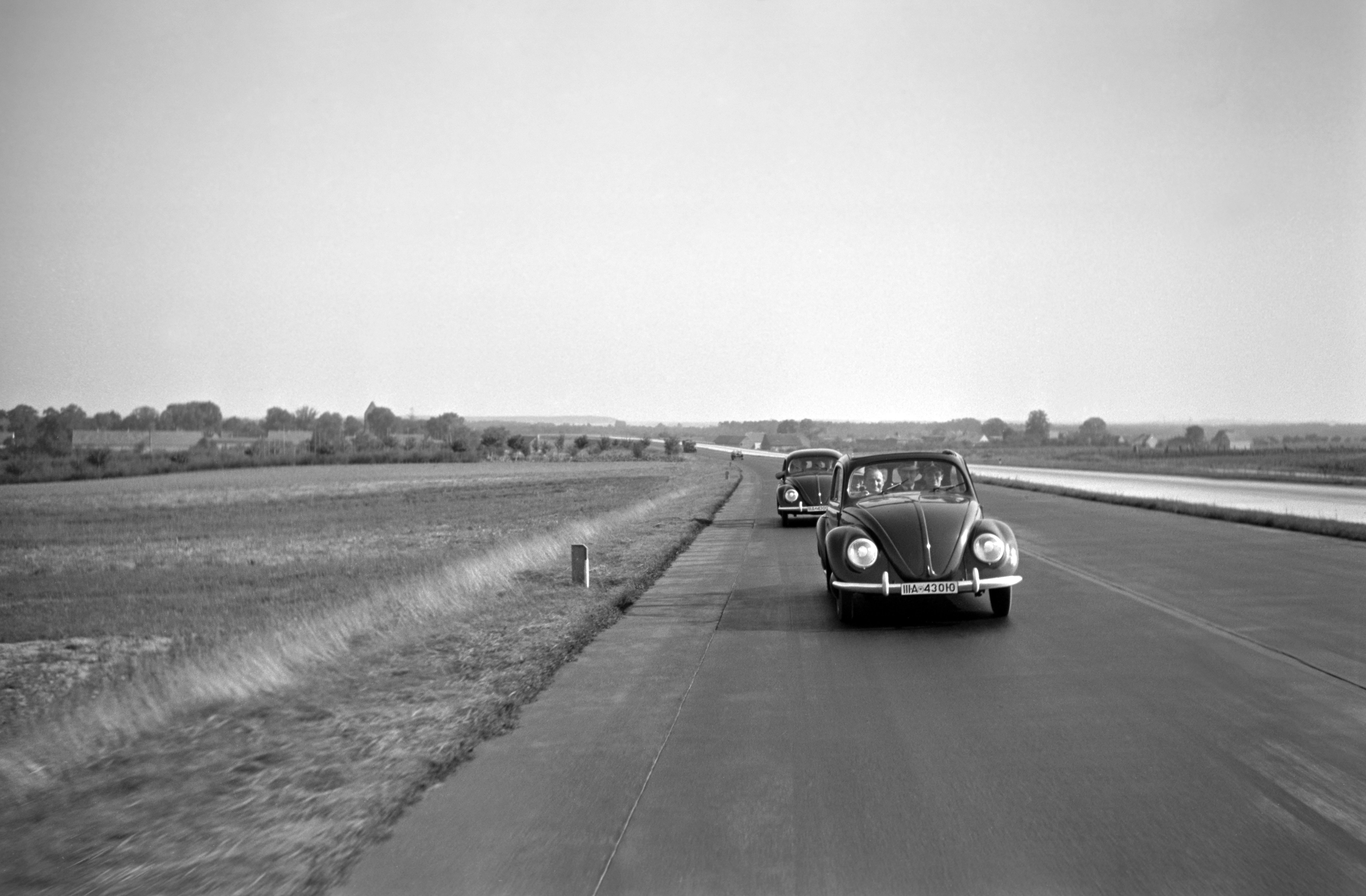 Henning Nolte Black and White Photograph - Two Volkswagen beetle on the highway, Germany 1938 Printed Later 