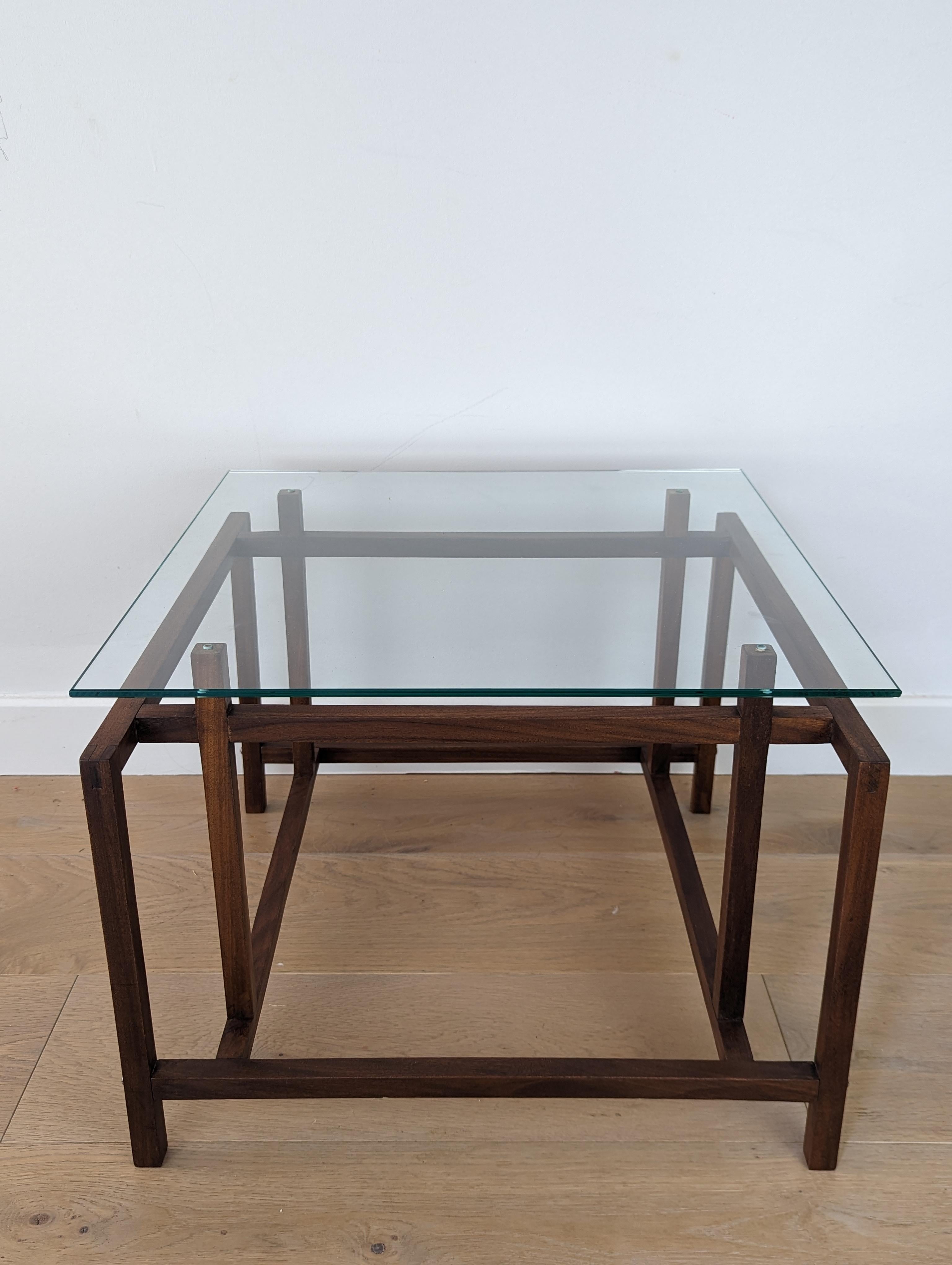 Henning Norgaard for Komfort side table in teak with glass table top.

This stunning little side/coffee table has a geometric teak base that is elegant and stylish. The glass table top sits delicately over the frame which has been restored to its