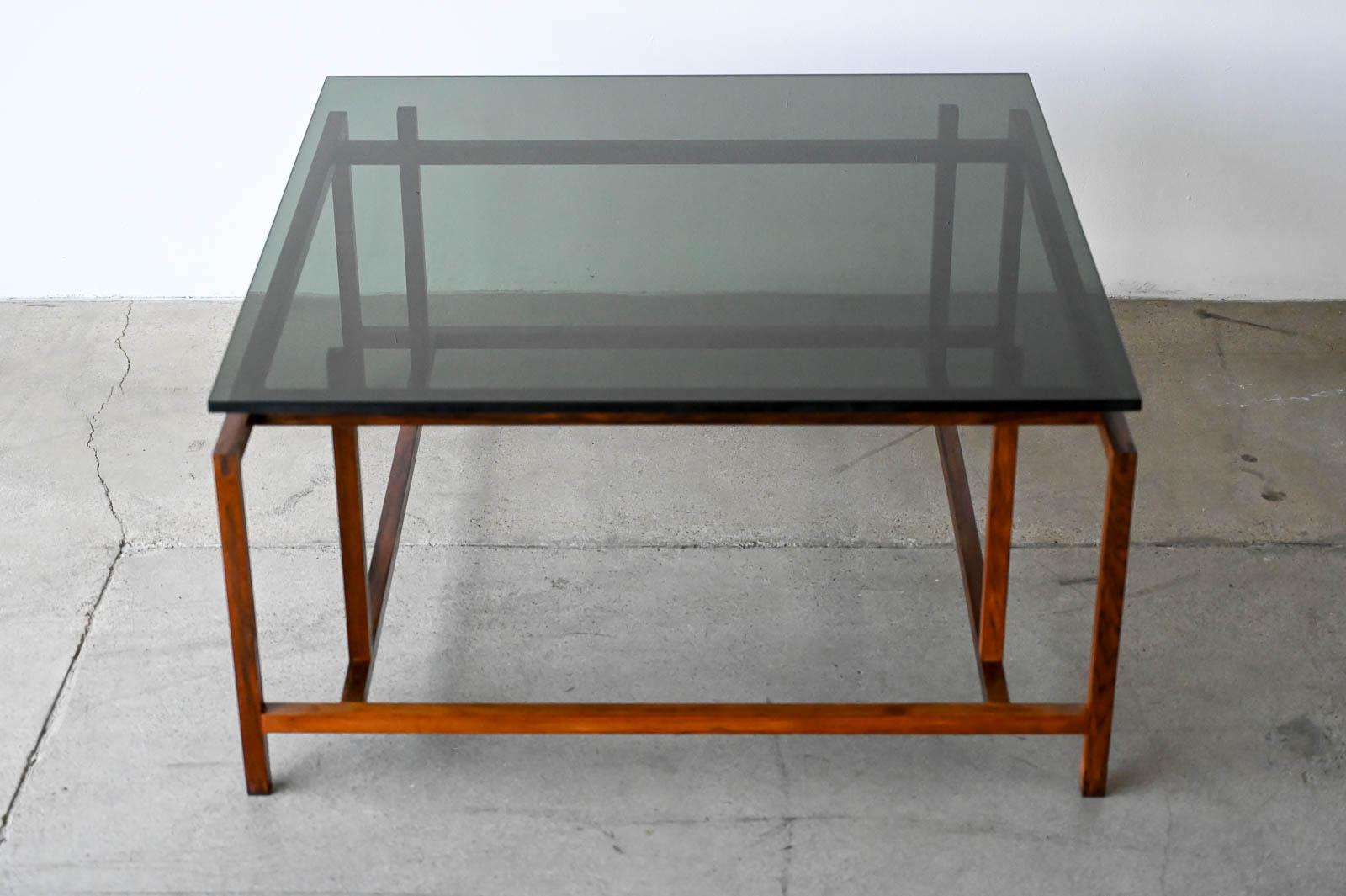 Henning Norgaard for Komfort Rosewood and Smoked Glass Coffee Table, ca. 1960.  Beautiful delicate rosewood frame with original smoked glass top that floats effortlessly on the notched frame.  Piece is in very good original condition with only