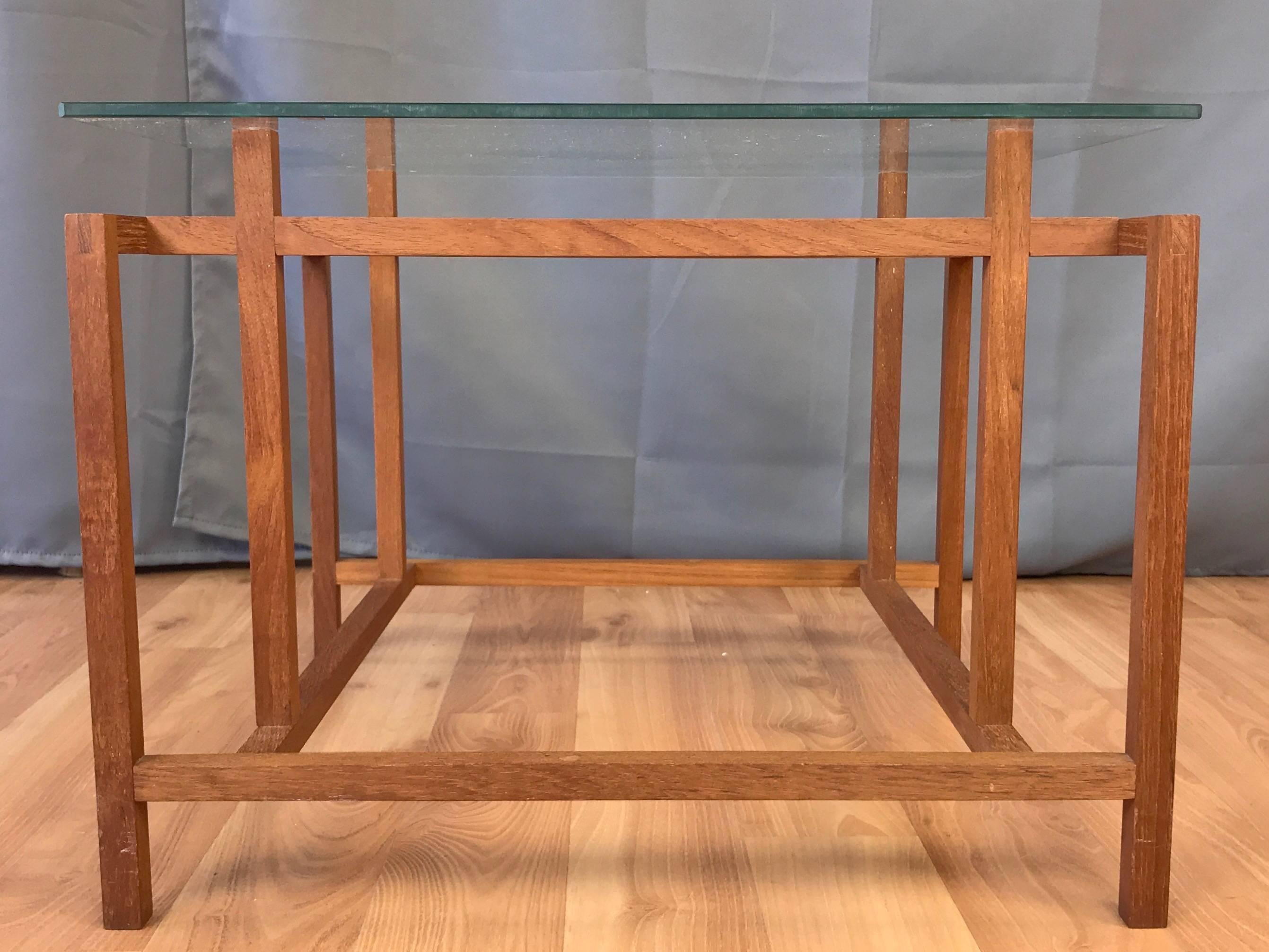 An architectural teak side or end table with glass top by Henning Nørgaard for Komfort.

Minimalist geometric solid teak base displays excellent craftsmanship, with both mortise-and-Tenon and finger joinery. Has original glass top. Retains