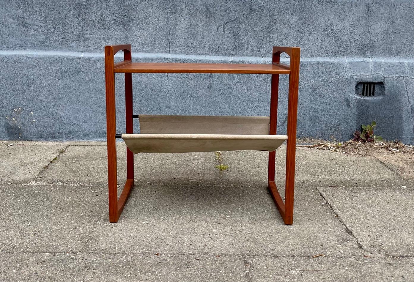 A well made/designed small handled side table with built-in magazine sling/rack in suede leather resting on patinated brass stand-offs. Fine and subtle details throughout this piece. Designed not by Kai Kristiansen but by Henning Wind Hansen and