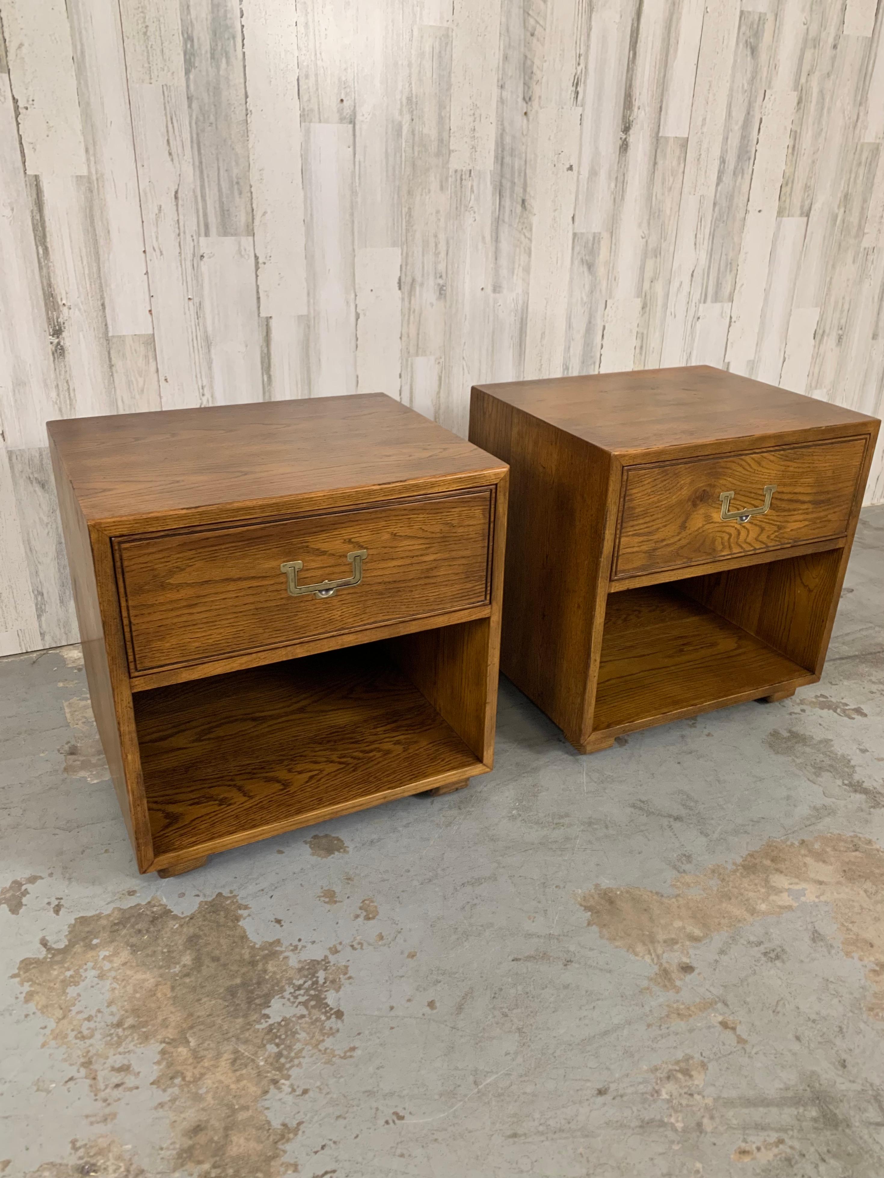 Nice pair of Campaign style night stands Made by Henredon's Artefact line, each has one drawer and one cubby hole with a receptacle for clock or radio. Very solid with heavy brass drawer pull. 