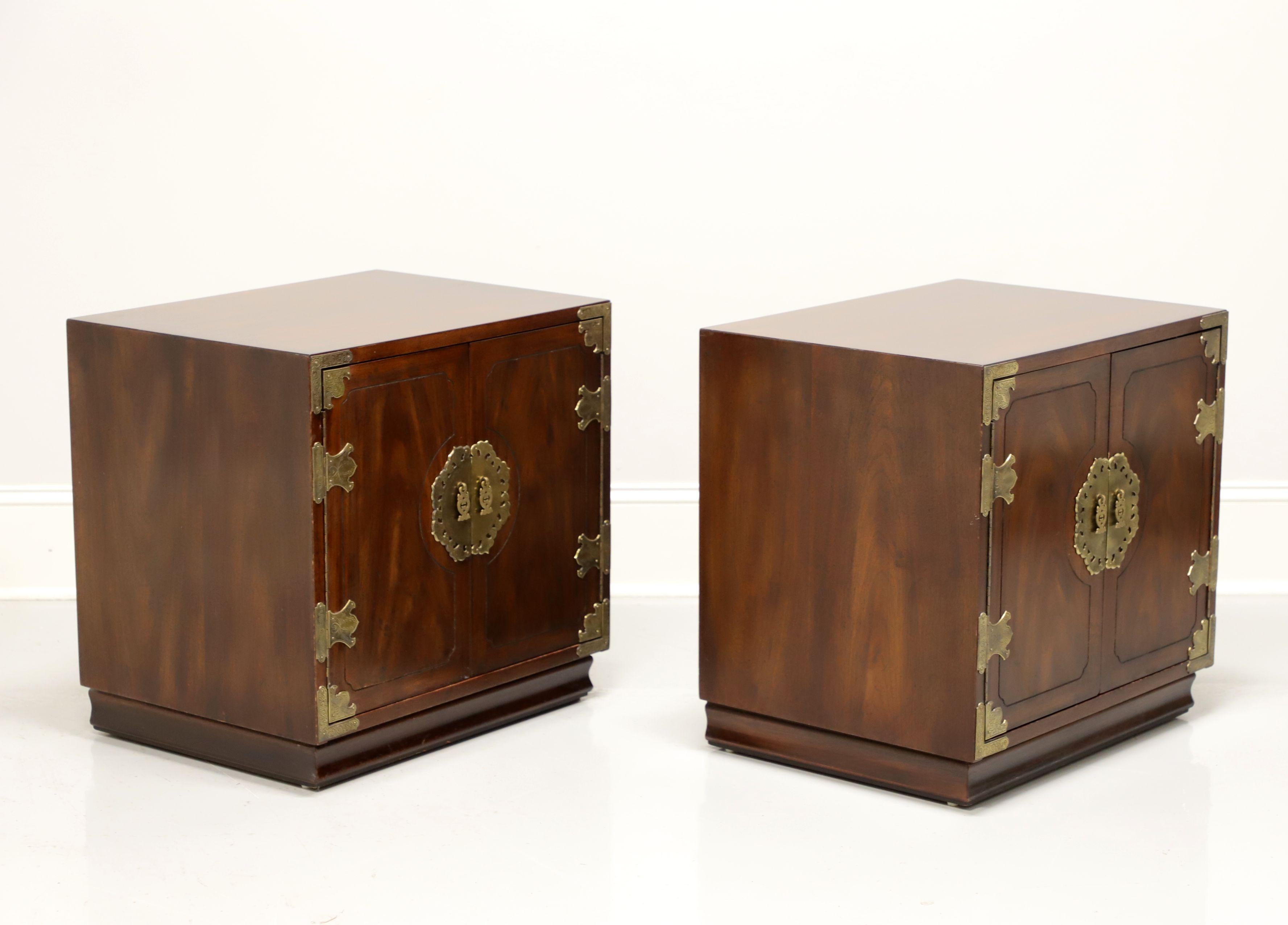 A pair of nightstands in the Japanese Tansu Campaign style by Henredon. Walnut with brass hardware and accents. Features dual doors revealing a storage area with one adjustable wood shelf. Made in Morganton, North Carolina, USA, circa