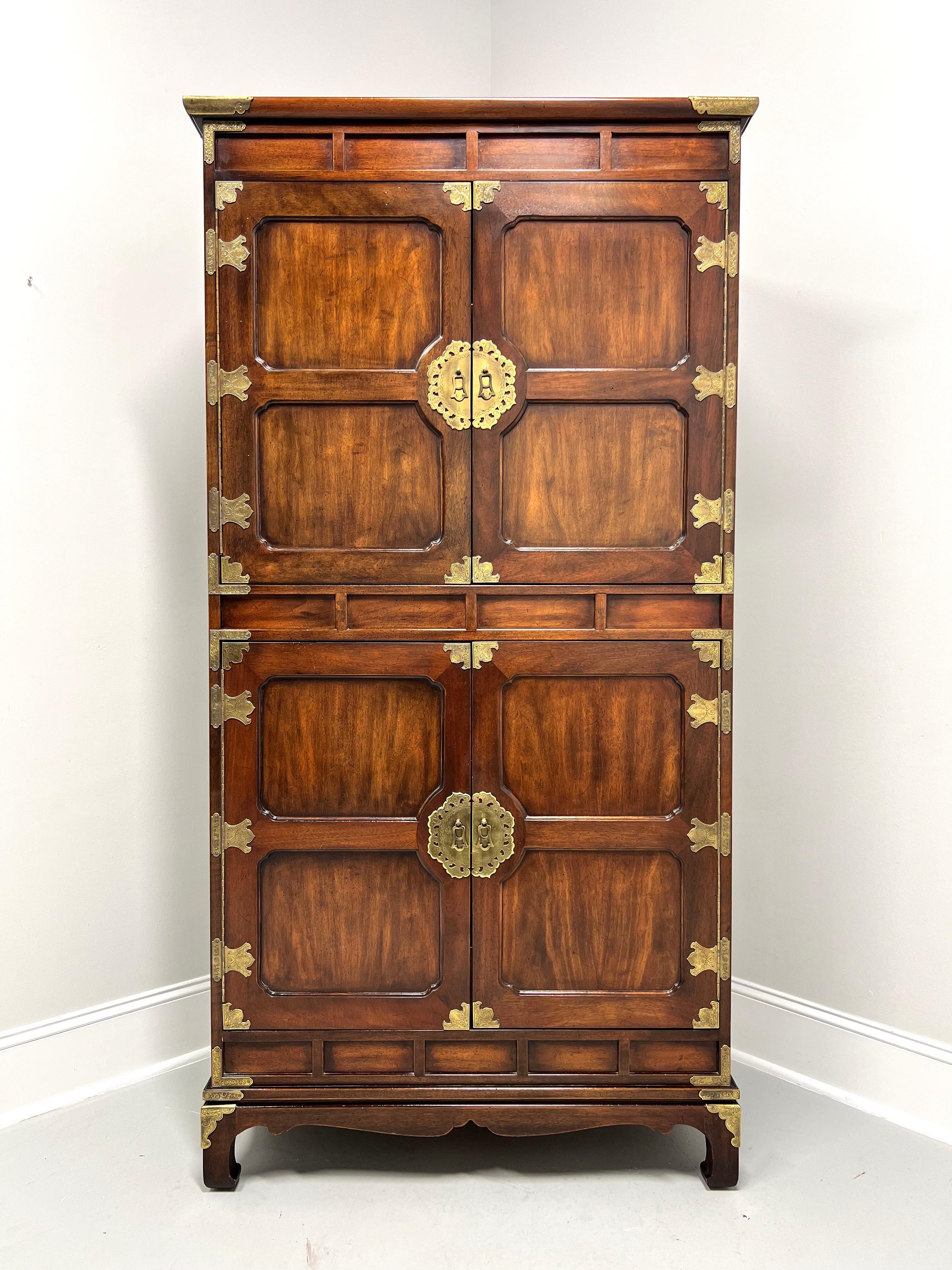An extra tall gentleman's chest in the Japanese Tansu Campaign style by Henredon. Mahogany with brass hardware & accents, overhanging top, decorative upper, center & lower panels, carved apron, and turned inward feet. Upper cabinet features two