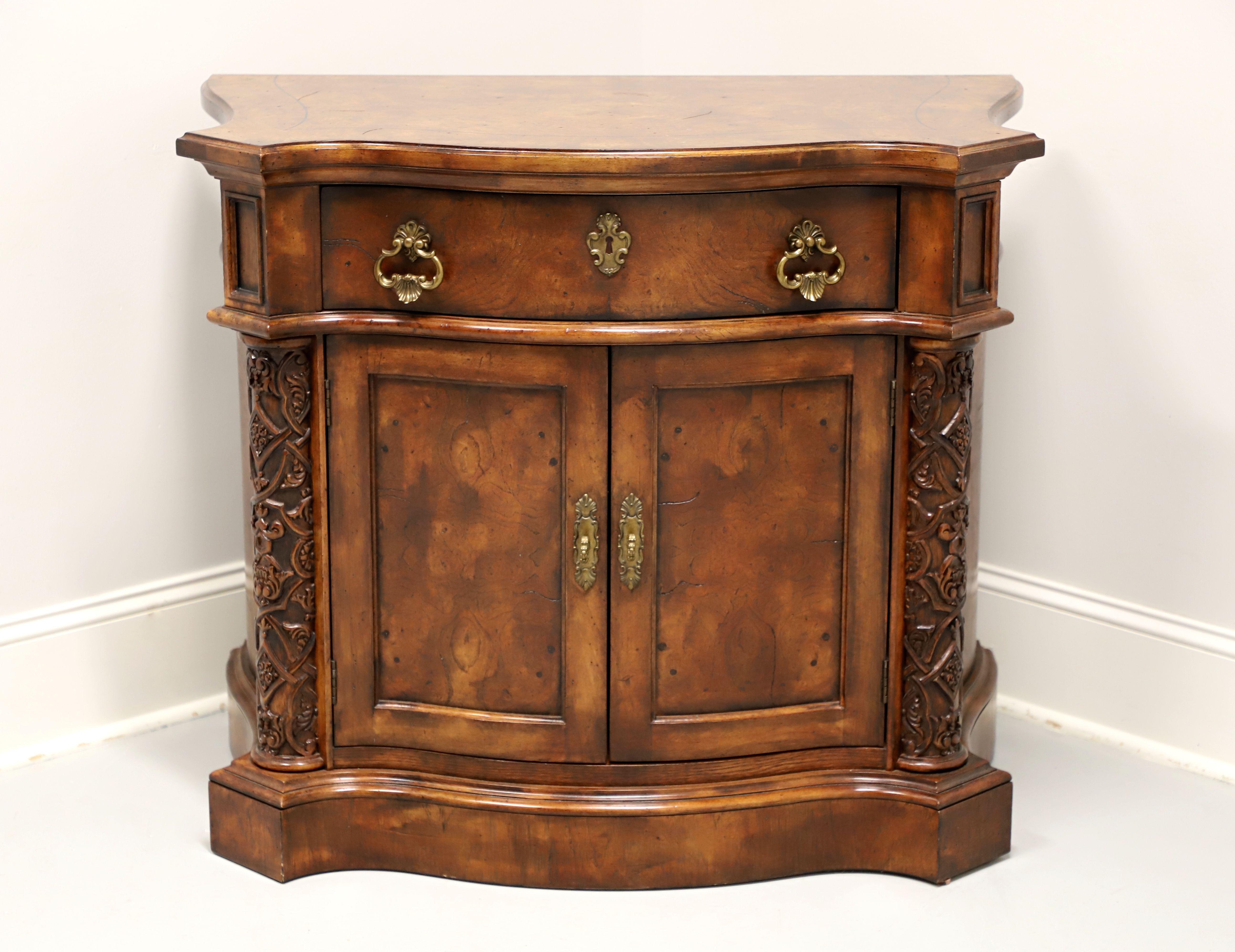 A Regency style commode cabinet by Henredon. Burl walnut with brass hardware; serpentine shape, bevel edge to top, protruded corners to front sides, elaborately carved columns at sides, and a solid base. Features one dovetail drawer with faux