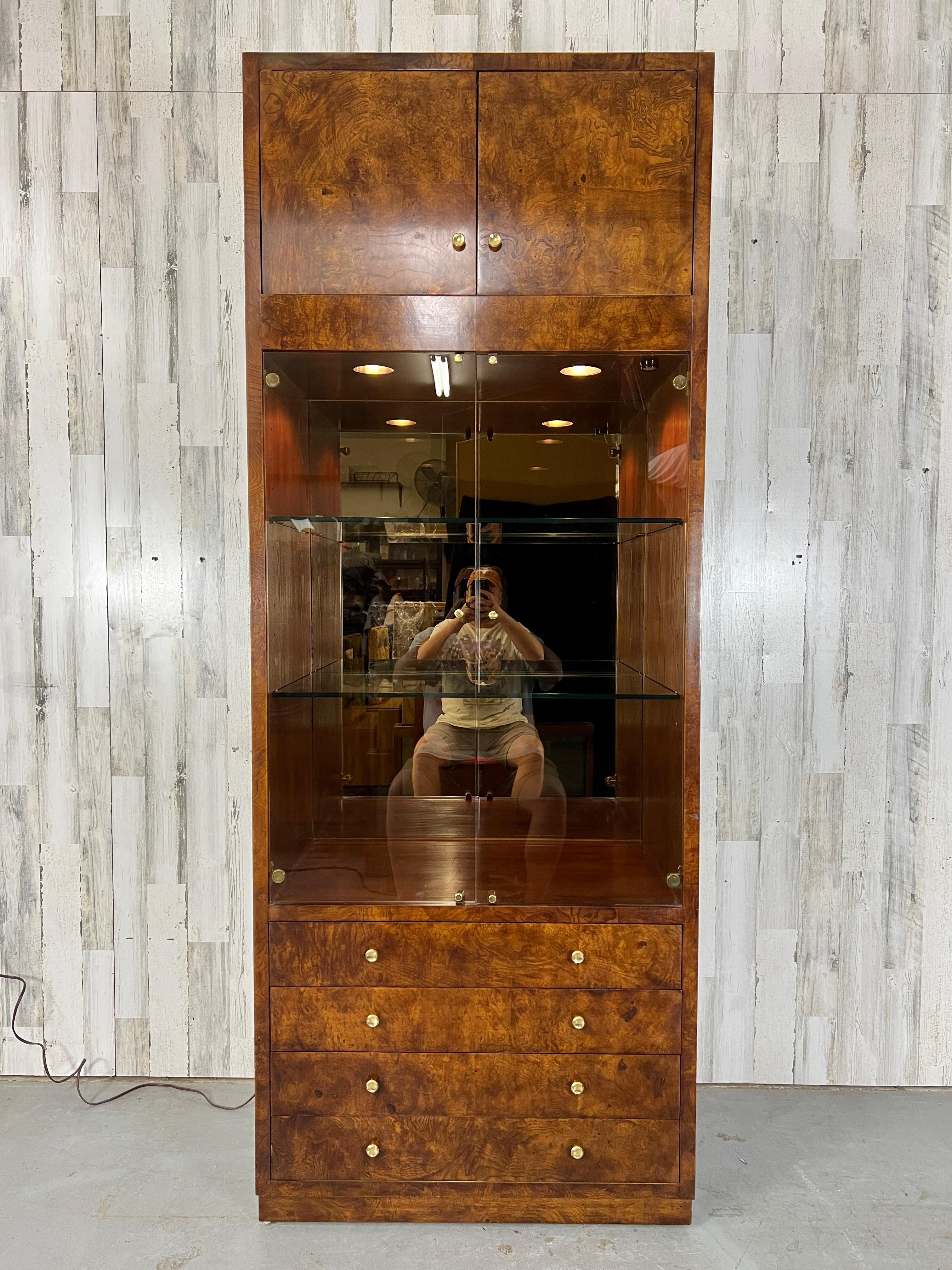 Elm burl wood veneer. Recessed lighting in the cabinet to illuminate the adjustable glass shelving. Smoked glass doors & smoked mirror backed. Brass hardware is a stunning accent to the burl wood.
Display area on the cabinet measures: 18 D x 31.5 W