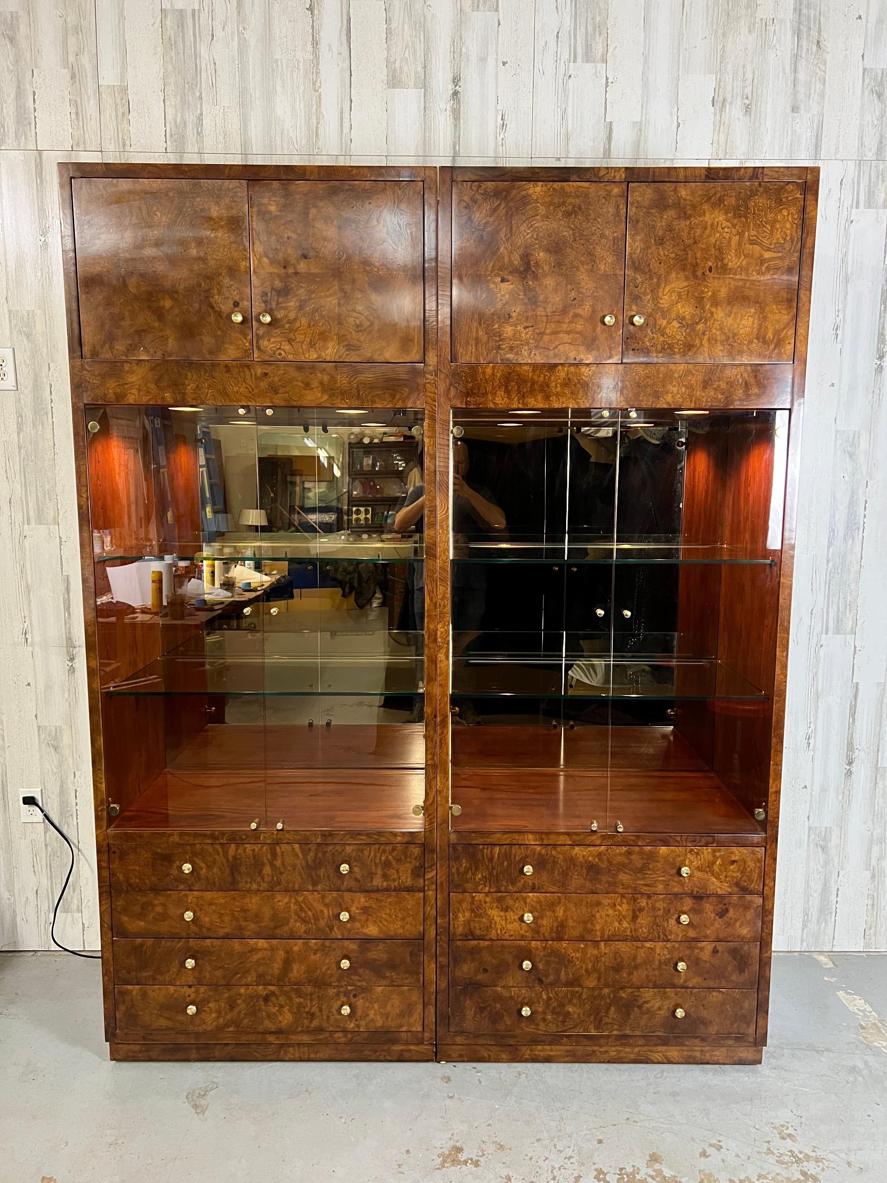 A pair of cabinets with elm burl wood veneer. Recessed lighting in two of the cabinets to illuminate the adjustable glass shelving. Smoked glass door & smoked mirror backed. Brass hardware is a stunning accent to the burl wood.
Display area on each
