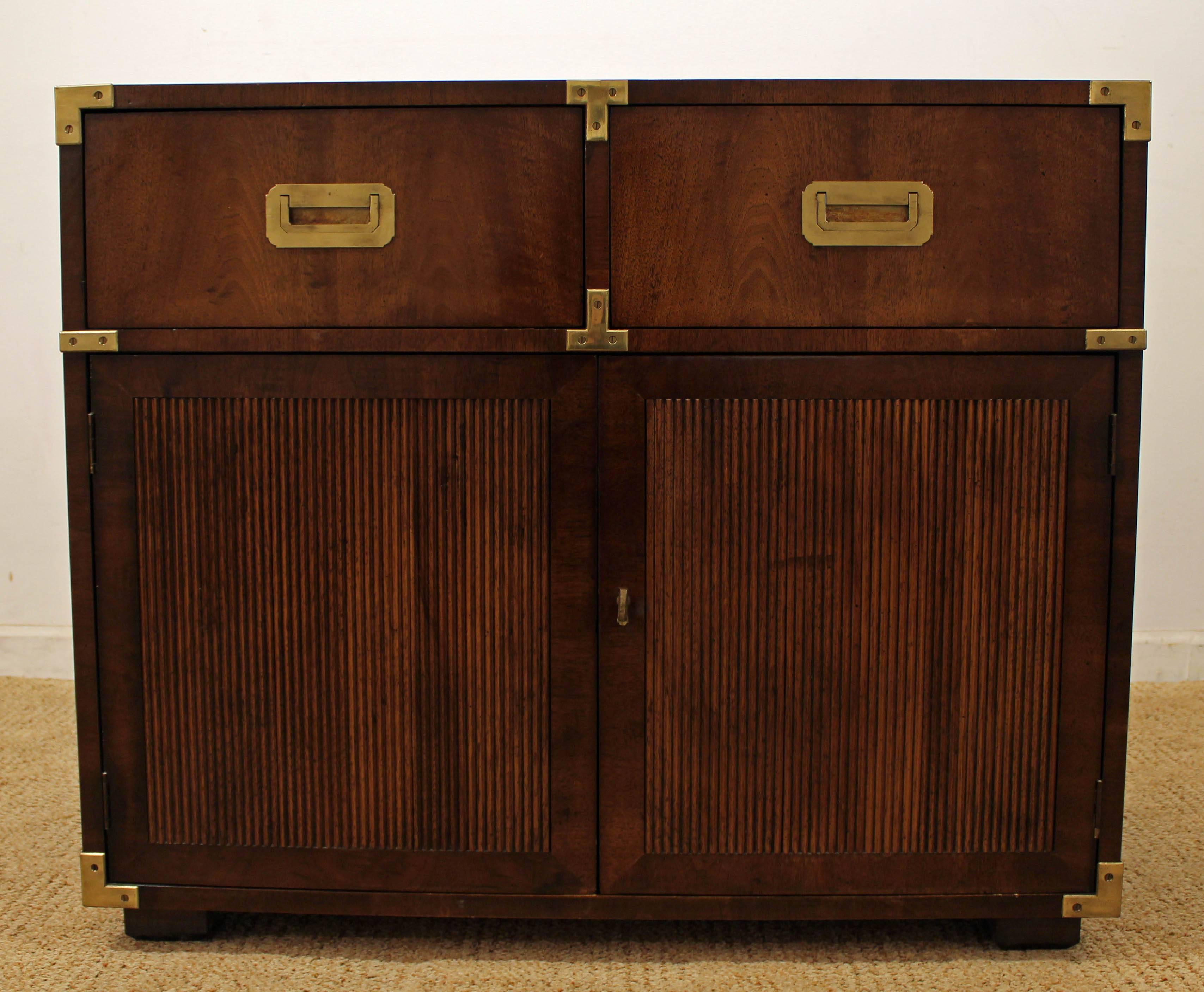 Offered is a great Campaign style made by Henredon, circa 1970s. Features two drawers with open storage (with shelf) below and brass hardware. It is in excellent condition showing minor age wear.

 Dimensions:
36