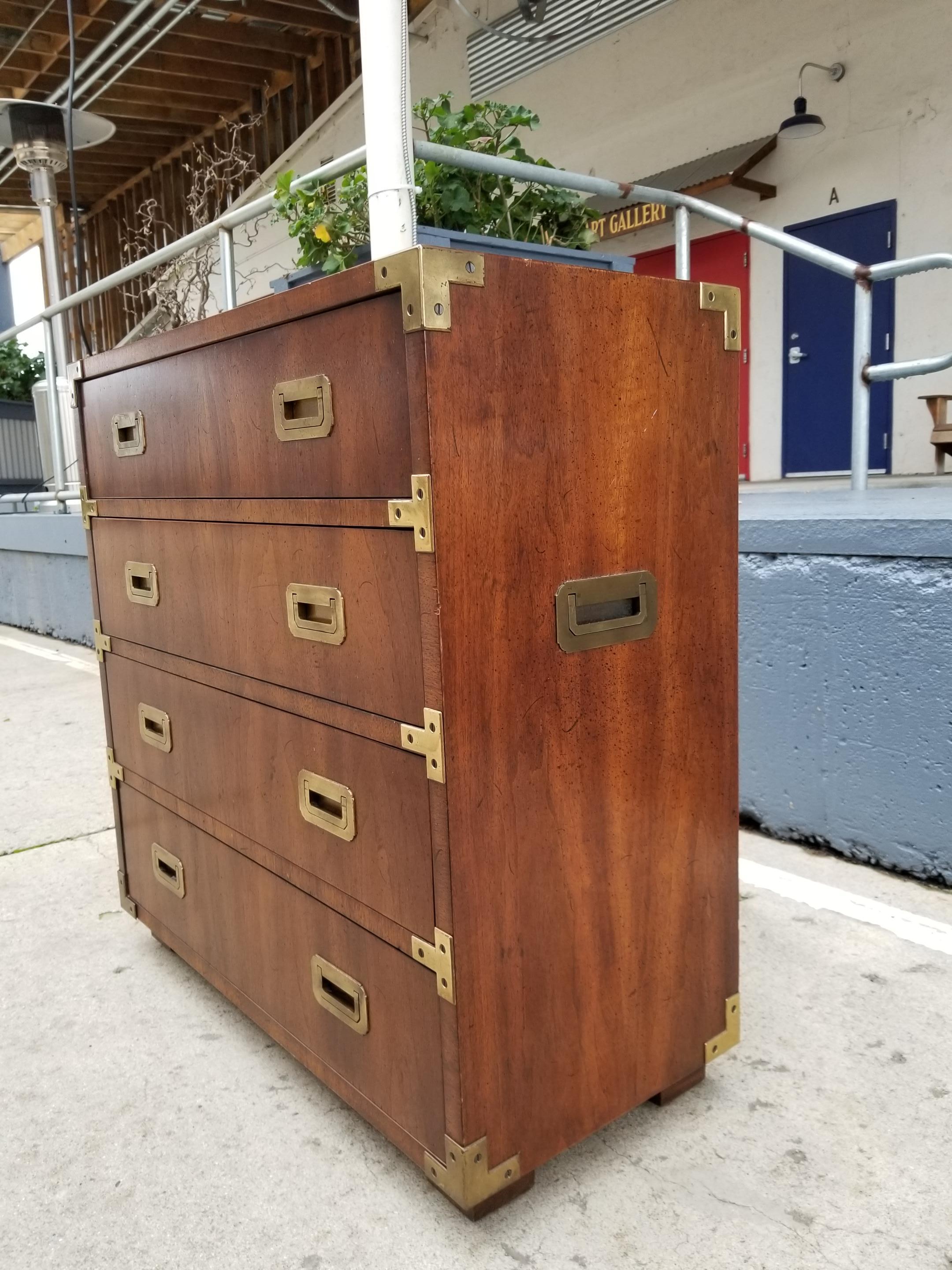 Fine craftsmanship in this small Campaign style dresser by Henredon Furniture. Burl-wood finish with solid brass hardware. Exceptional original condition. Branded Henredon on drawer interior. Diminutive size would offer multiple use as end table or