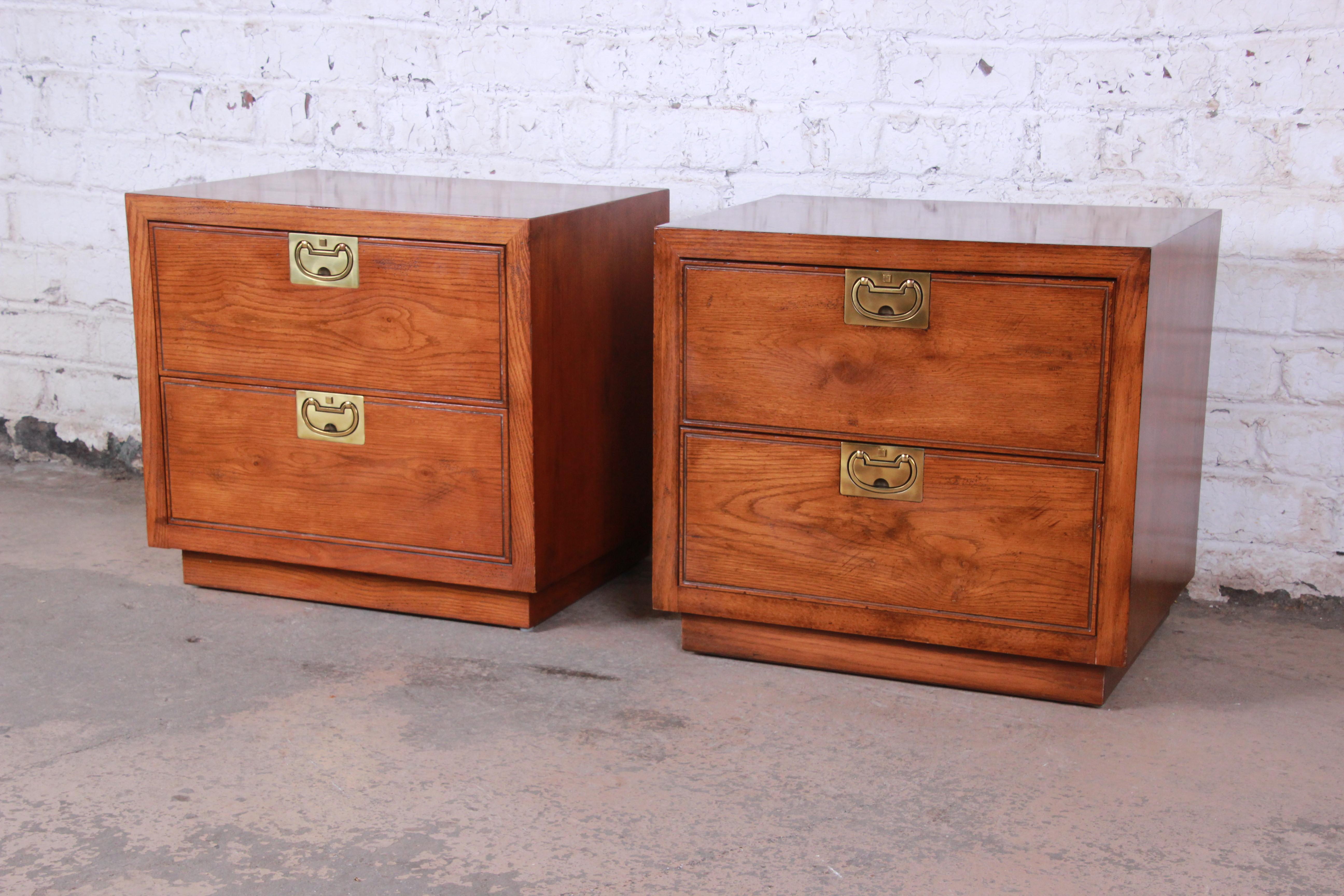 Offering a very nice pair of Henredon Campaign style oak nightstands from the Bel Air line. The nightstands have nice brass pulls with two large drawers for storage on each stand. They offer a beautiful oakwood grain and are in great vintage