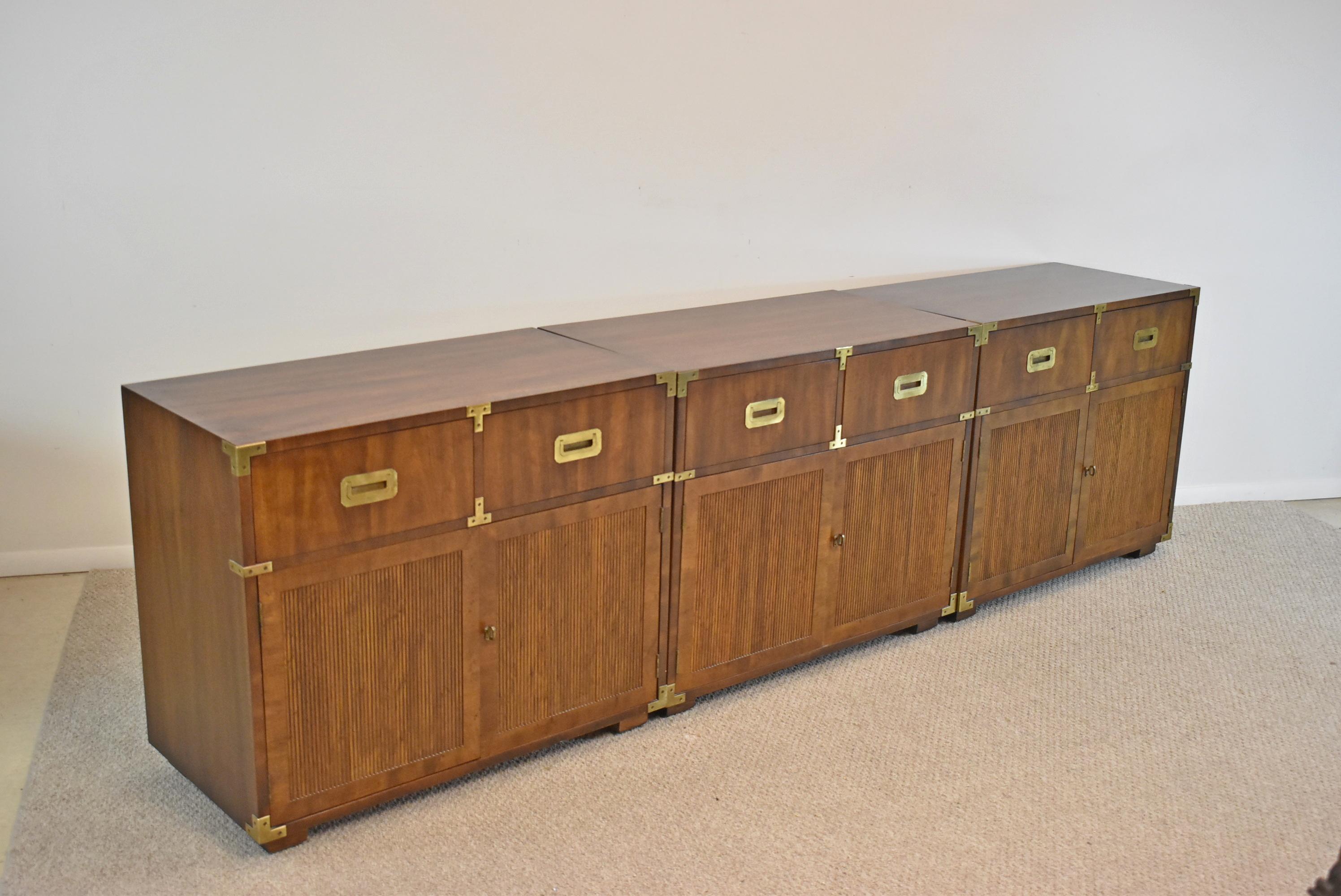 Henredon Campaign Style Walnut chests, 3 available sold separately. Circa 1975. Beautiful Henredon Campaign Chests with a beautiful distressed finish. Two drawers with open storage, with an adjustable shelf below. Handsome solid brass hardware and