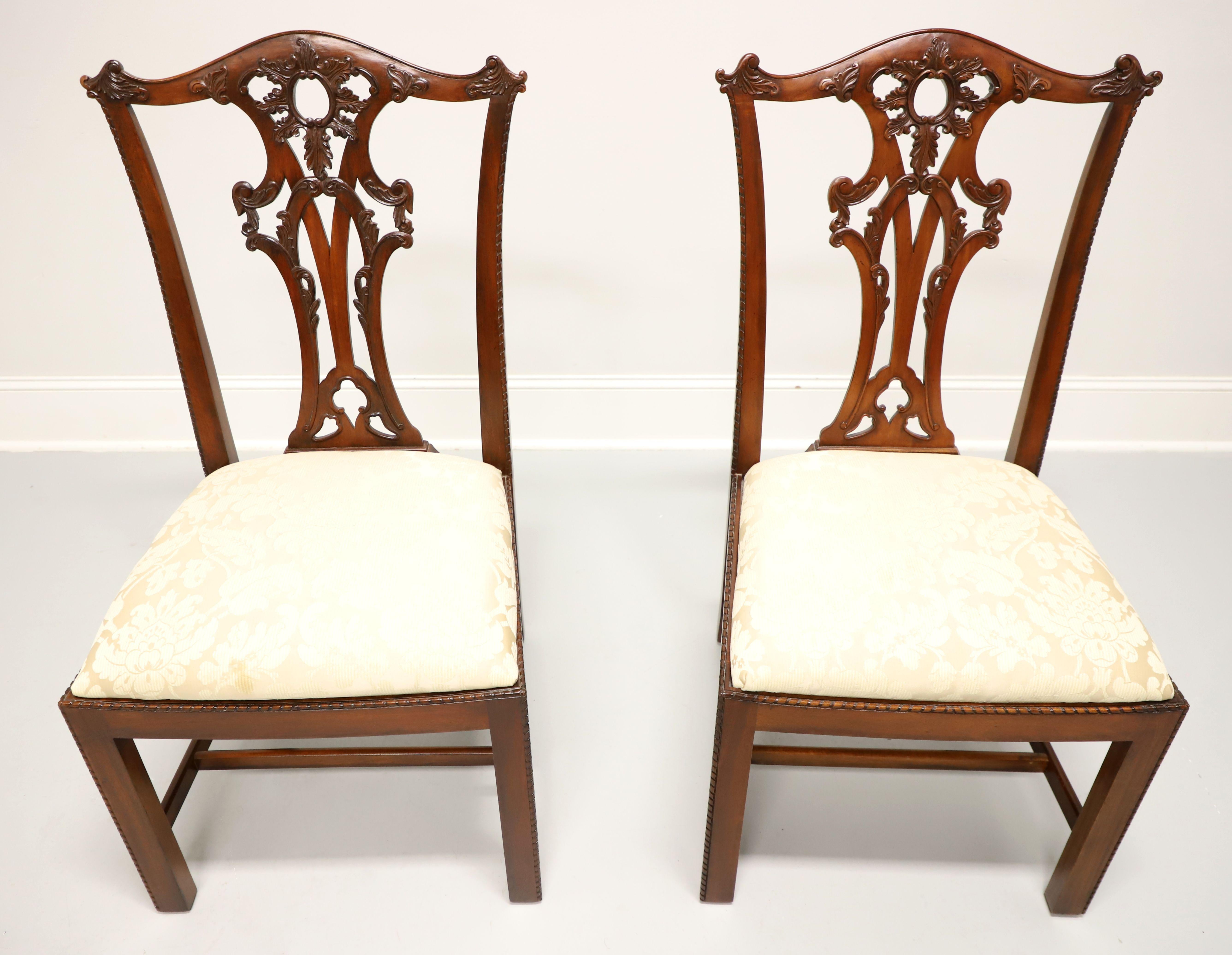 A pair of Chippendale style dining side chairs by Henredon. Solid mahogany with decoratively carved crest rail, back rest, carved beading to edge of stiles, seat edge & edges of the front straight legs with stretchers. Seat upholstered in a neutral