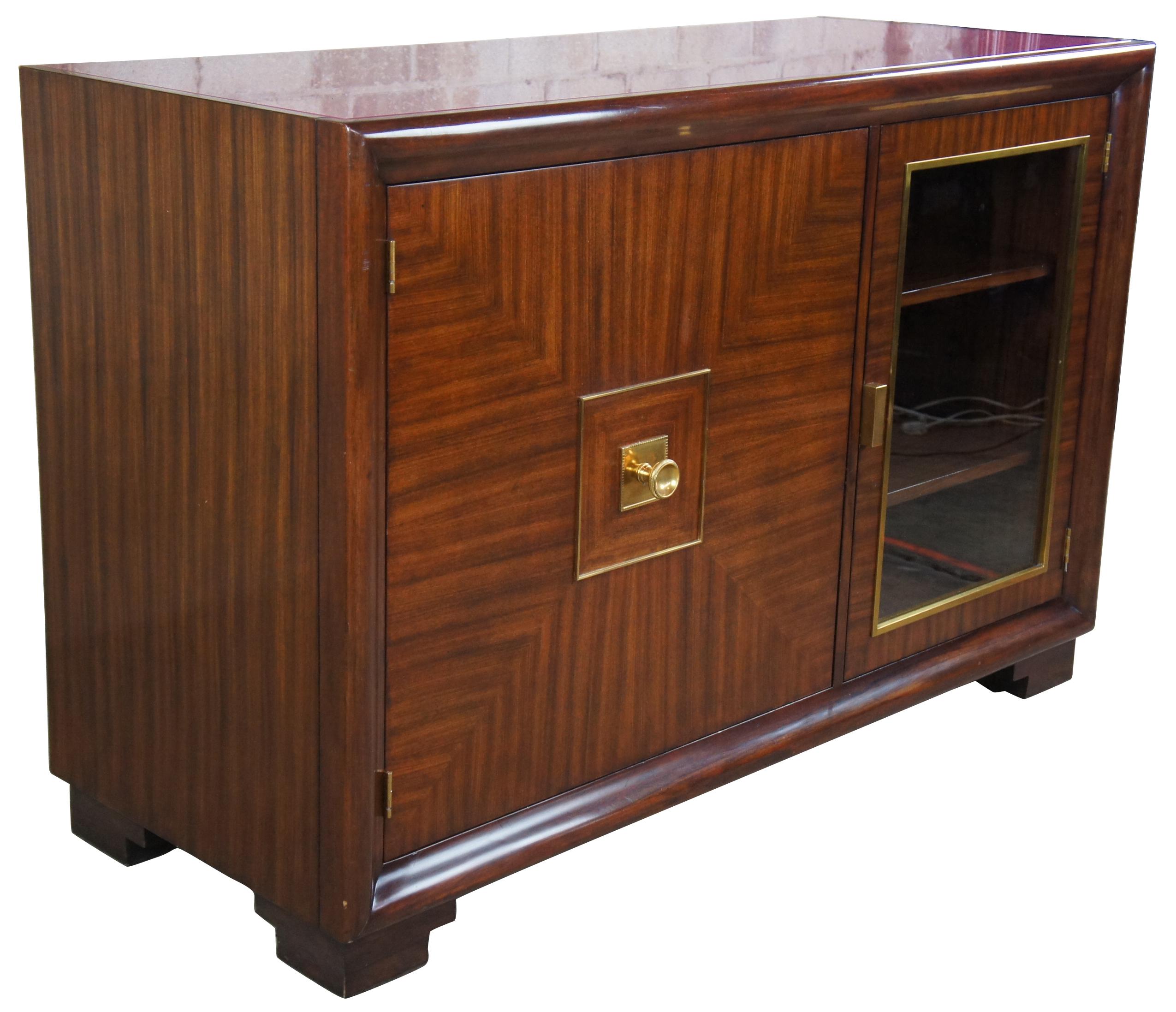 The Henredon Celerie Kemble Andrew Server features an asymmetric front divided into one large cabinet with drawers and a glass front. Made from rosewood veneers that add a geometric touch on the server front. The top is covered with a maroon glass