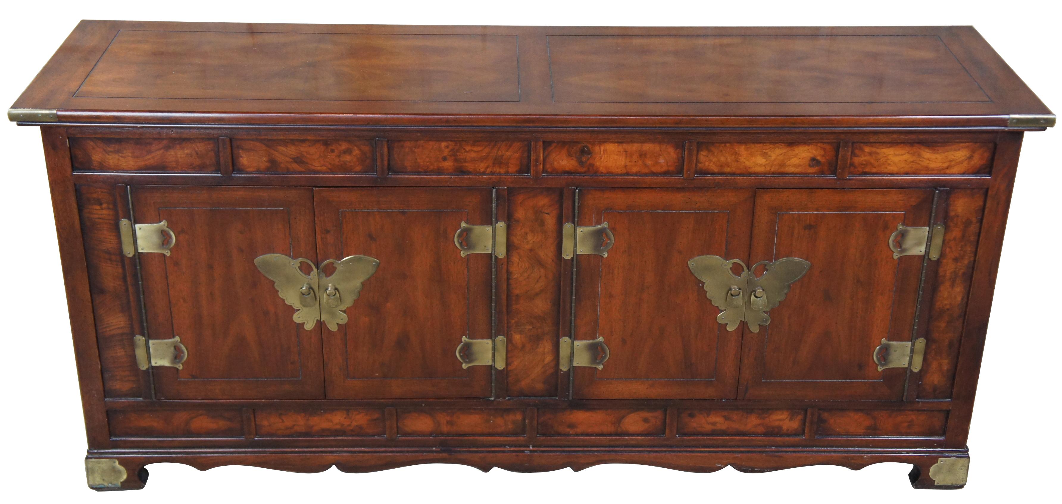 Circa 1980s Henredon Butterfly cabinet. Features campaign styling with burled panels, brass mounts, and brass butterfly hardware along the doors. The top is neatly designed with a matchbook veneer mirroring the wings of the butterfly.
        