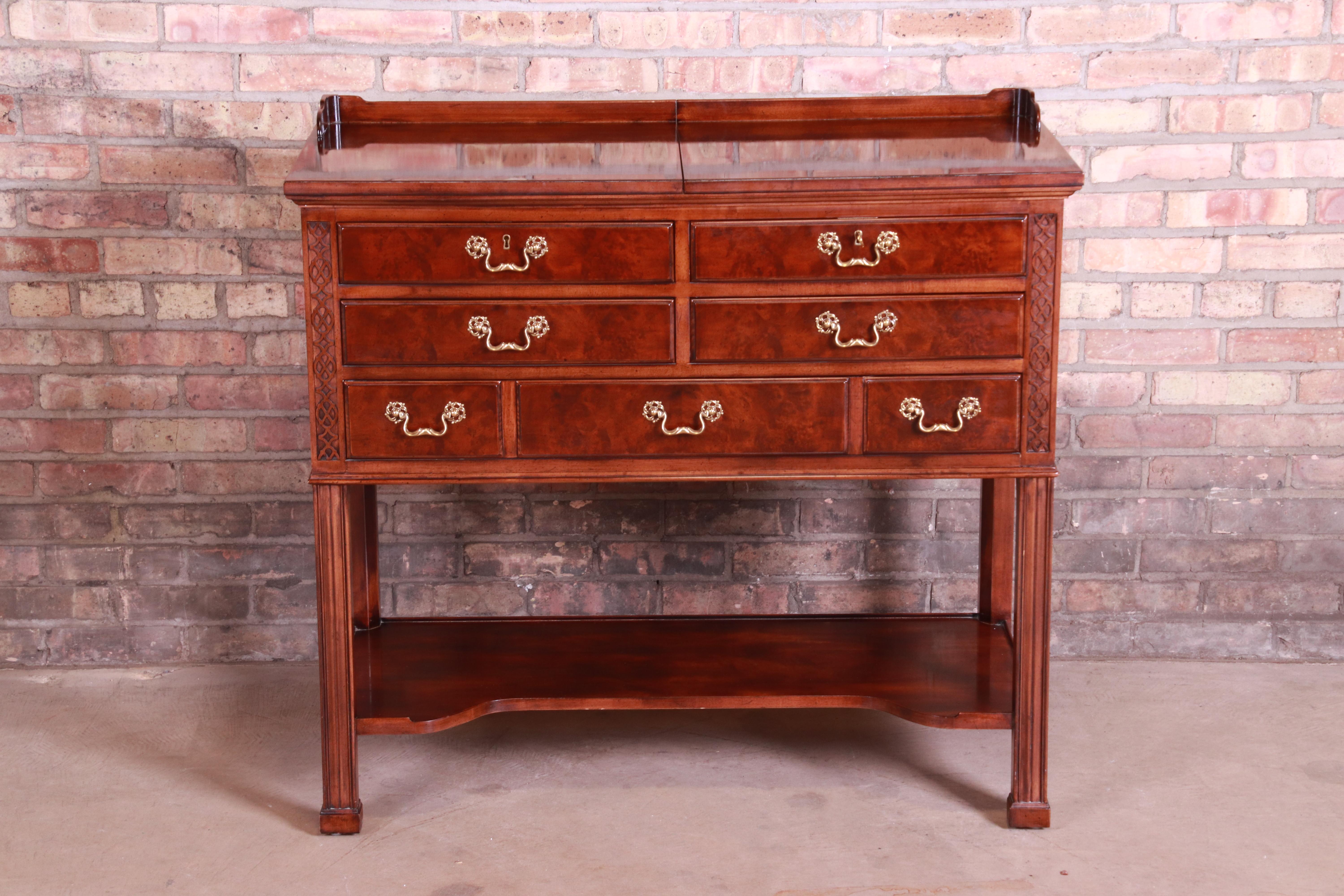 An exceptional Chippendale style five-drawer flip top dry bar or buffet server

By Henredon,

USA, 1980s

Carved mahogany, with burl wood drawer fronts, original brass hardware, and felt inserts for barware.

Measures: 40.13