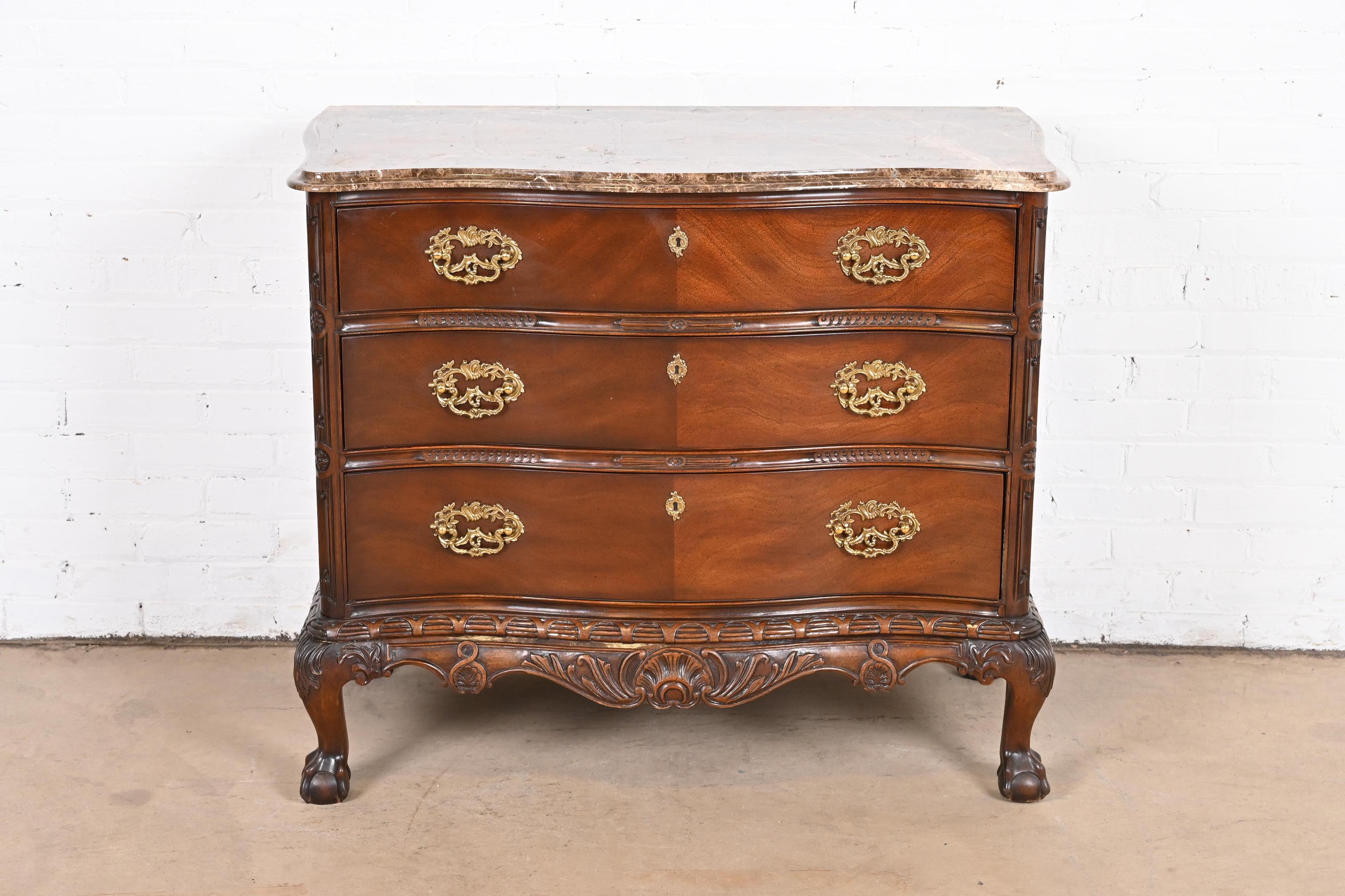 A gorgeous Chippendale or Georgian style commode or chest of drawers

By Henredon

USA, circa 1990s

Carved mahogany, with thick beveled marble top, and original brass hardware.

Measures: 39.5
