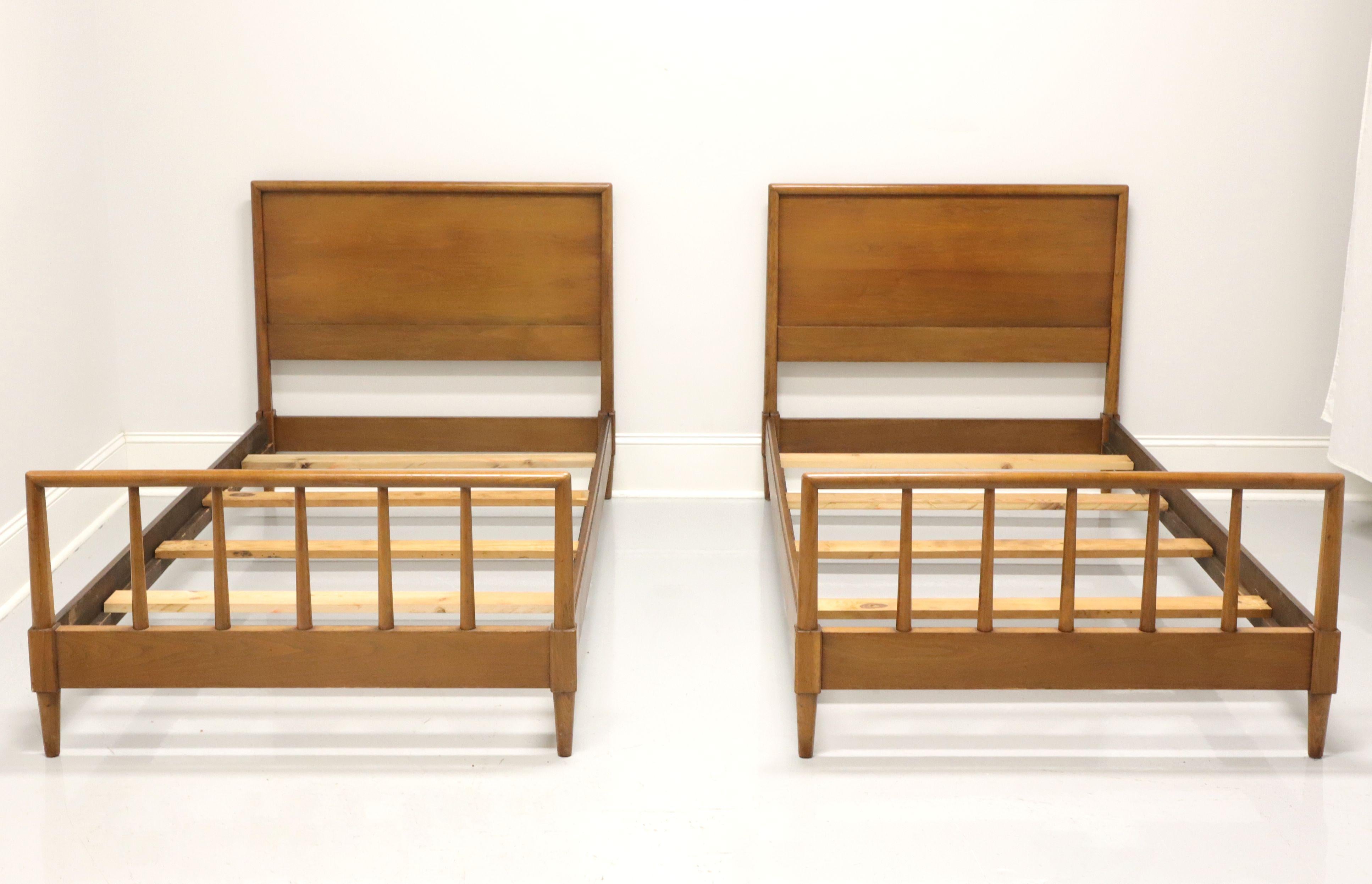 A pair of Mid-Century Modern twin beds by Henredon, from their Circa '60 Collection. Solid walnut headboard and matching footboard with open accents. Side rails connect the headboard and footboard, with wood slats providing mattress support. Made in