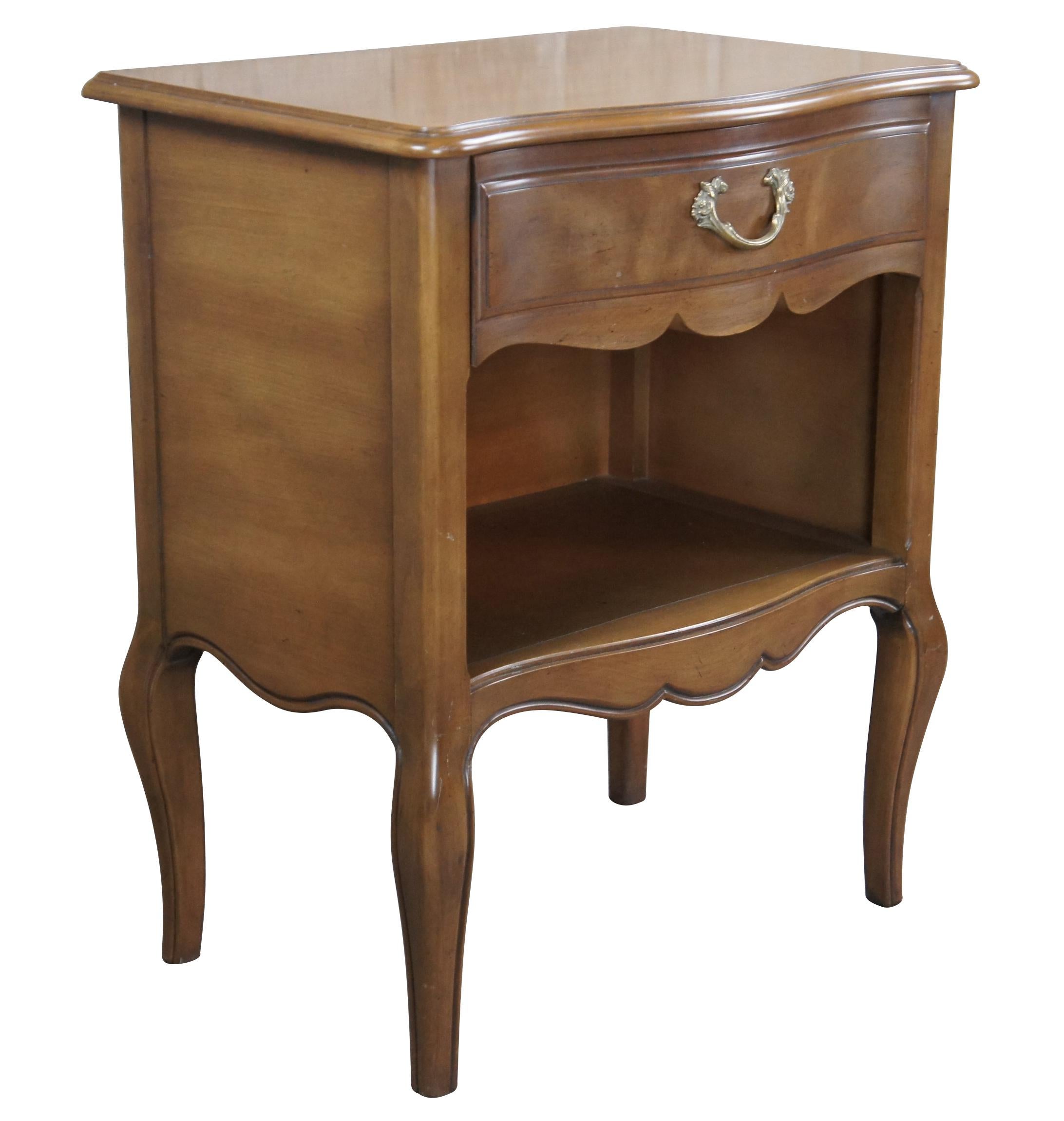 French Provincial bedside end table by Henredon Fine Furniture, circa 1970s. Features a serpentine frame made from American tulip wood with a dovetailed drawer over lower cubby with plug. The table is supported by cabriole legs. #9500