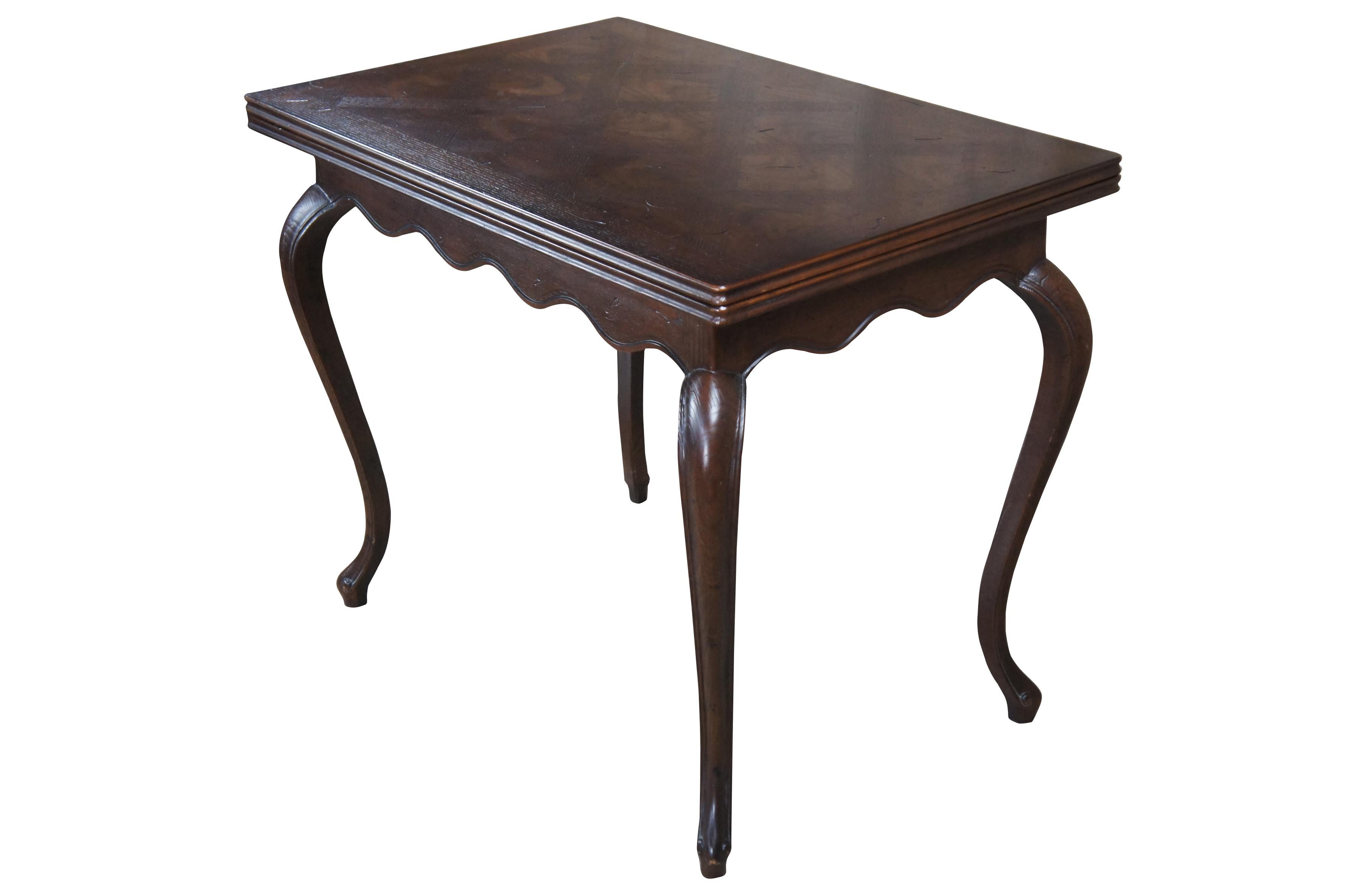 A lovely French Country swivel top game / dining table by Henredon.  Part of the Four Centuries Collection, circa 1970s.  Features a rectangular frame made from oak with parquetry top that swivels and opens doubling in size.  Includes a unique