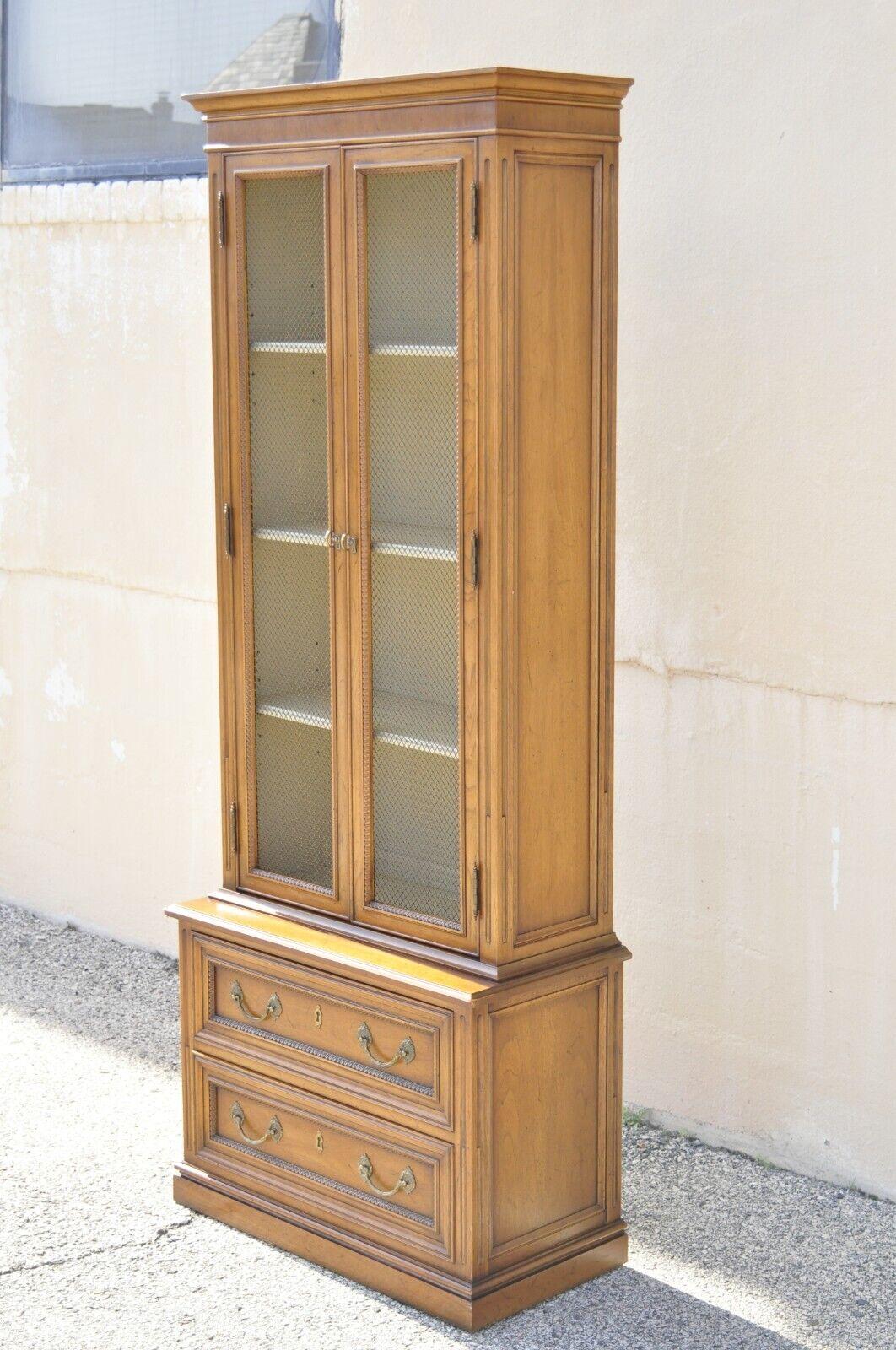 Henredon Custom Folio One Walnut French Provincial Style Tall Narrow Display Cabinet Curio. Item features metal grille door fronts, beautiful wood grain, distressed finish, 2 swing doors, original stamp, 2 dovetailed drawers, 2 adjustable shelves,