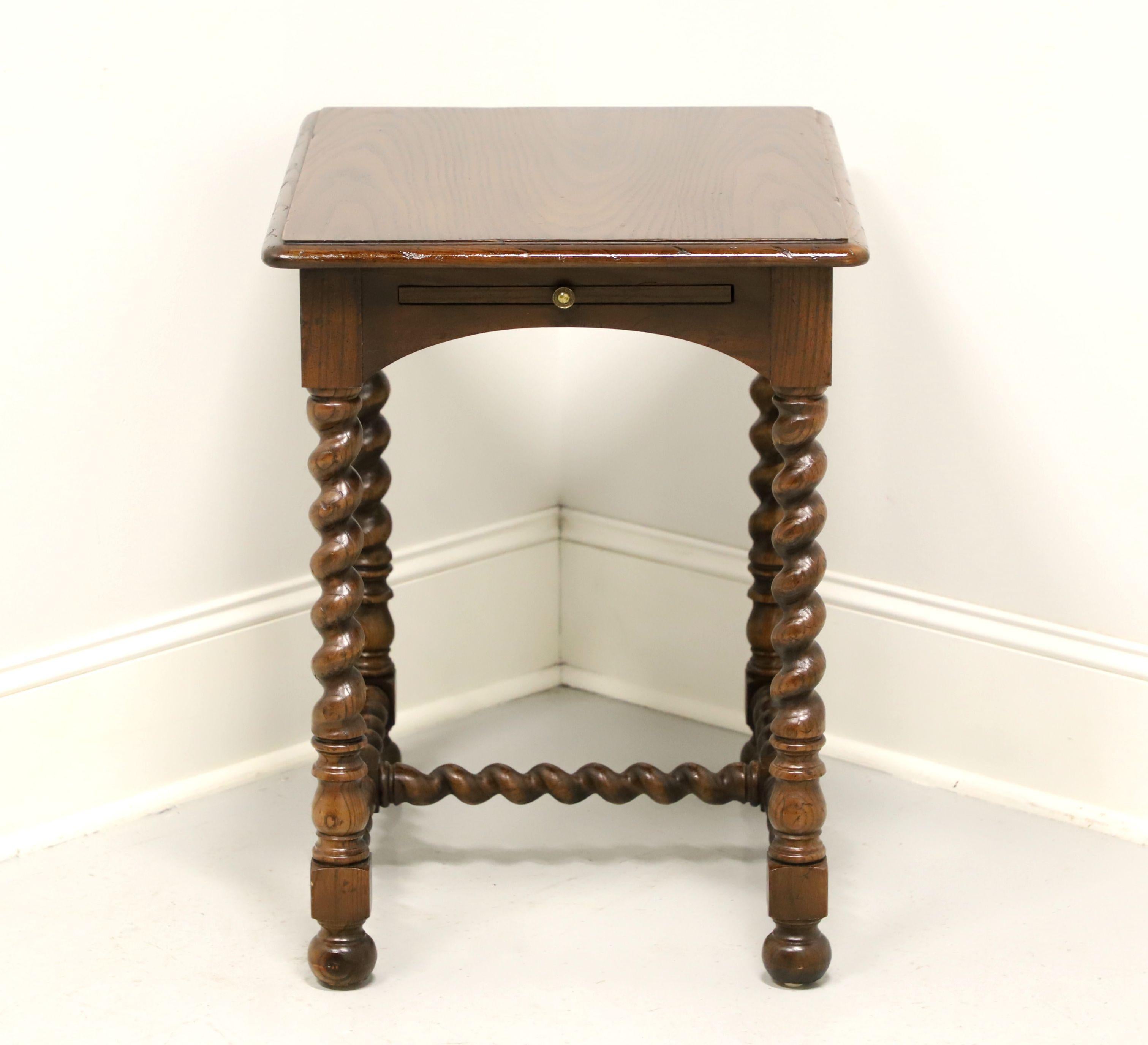 A French Country style side table by Henredon. Oak with a dark stain, slight distressing, pull-out tray, barley twist legs and stretchers. Features a laminate top pull-out tray surface with a brass knob. Made in Morganton, North Carolina, USA, in